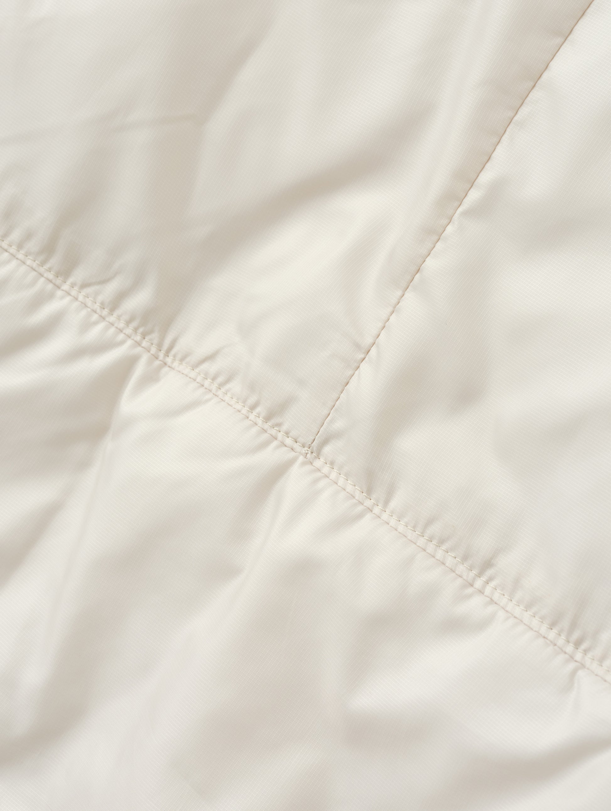 Closeup detailed view of the back seam on the Celeste Eco Insulated Hoodie in Bone from AETHER Apparel.