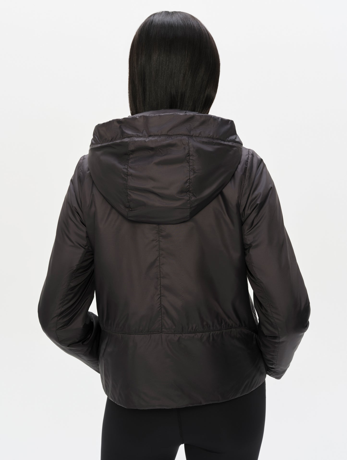 Rear upper-body view of woman wearing the Celeste Eco Insulated Hoodie in Onyx Black from AETHER Apparel.