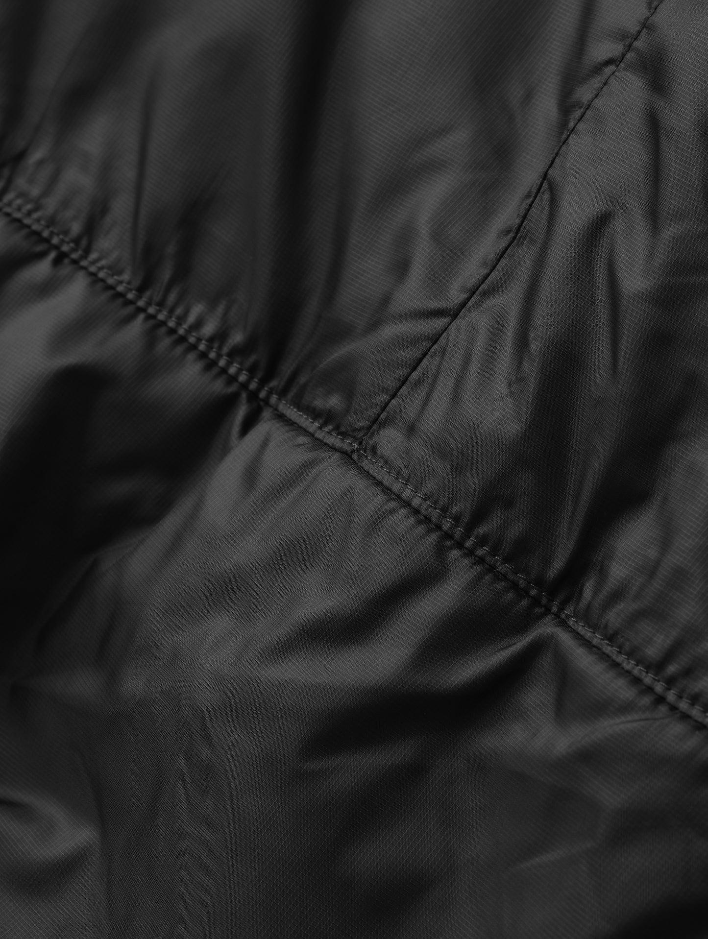 Closeup detailed view of the back seam on the Celeste Eco Insulated Hoodie in Onyx Black from AETHER Apparel.