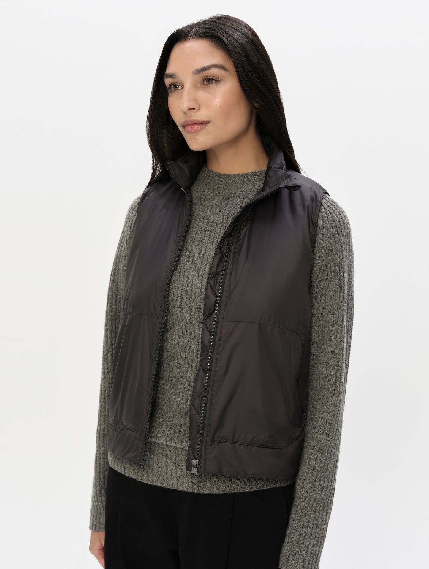Front, angled upper-body view of woman wearing the Celeste Eco Insulated Vest in Onyx Black from AETHER Apparel.