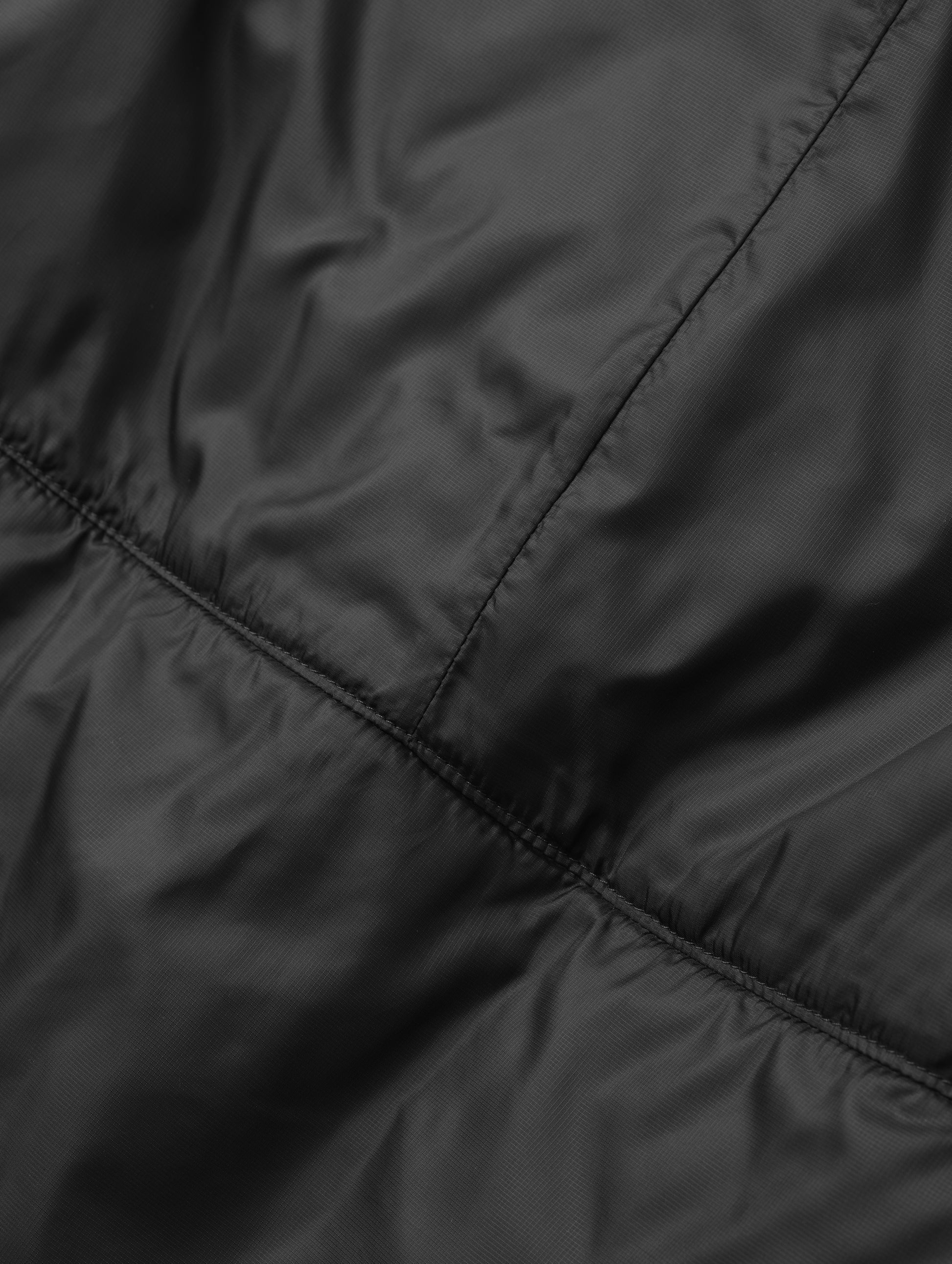 Closeup detailed view of the back seam on the Celeste Eco Insulated Vest in Onyx Black from AETHER Apparel.