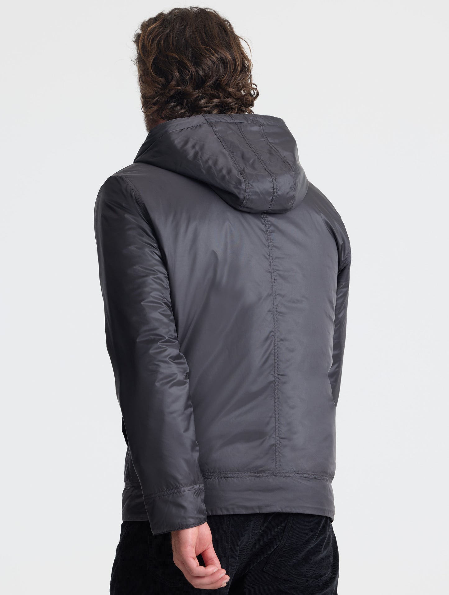 Rear view of man wearing Eco Space Hoodie in Onyx Black from AETHER Apparel.
