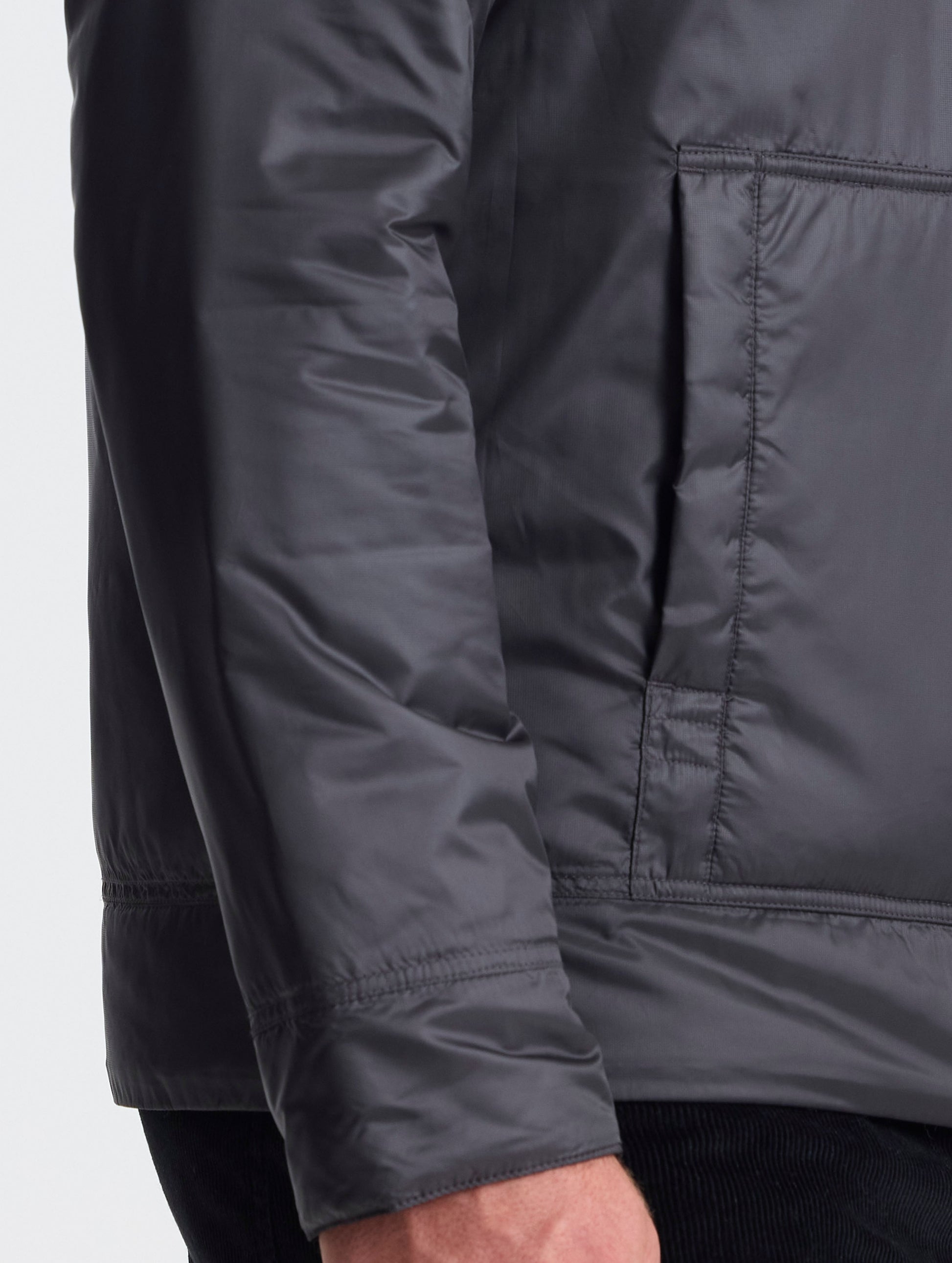 Closeup view of wearer's right hand pocket of Eco Space Hoodie in Onyx Black from AETHER Apparel.