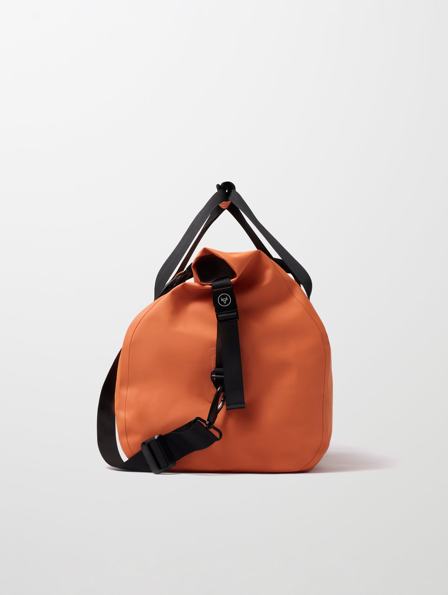 Side profile view of Excursion Duffle Bag 45L in Autumn Orange from AETHER Apparel.