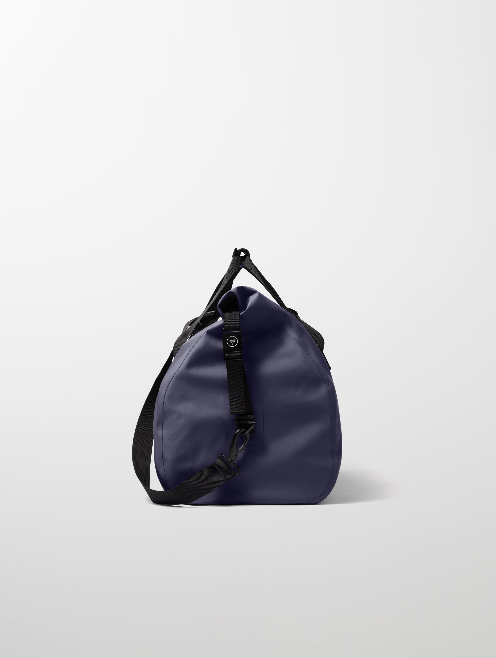 Side profile view of Excursion Duffle Bag 60L in Total Eclipse dark blue from AETHER Apparel.