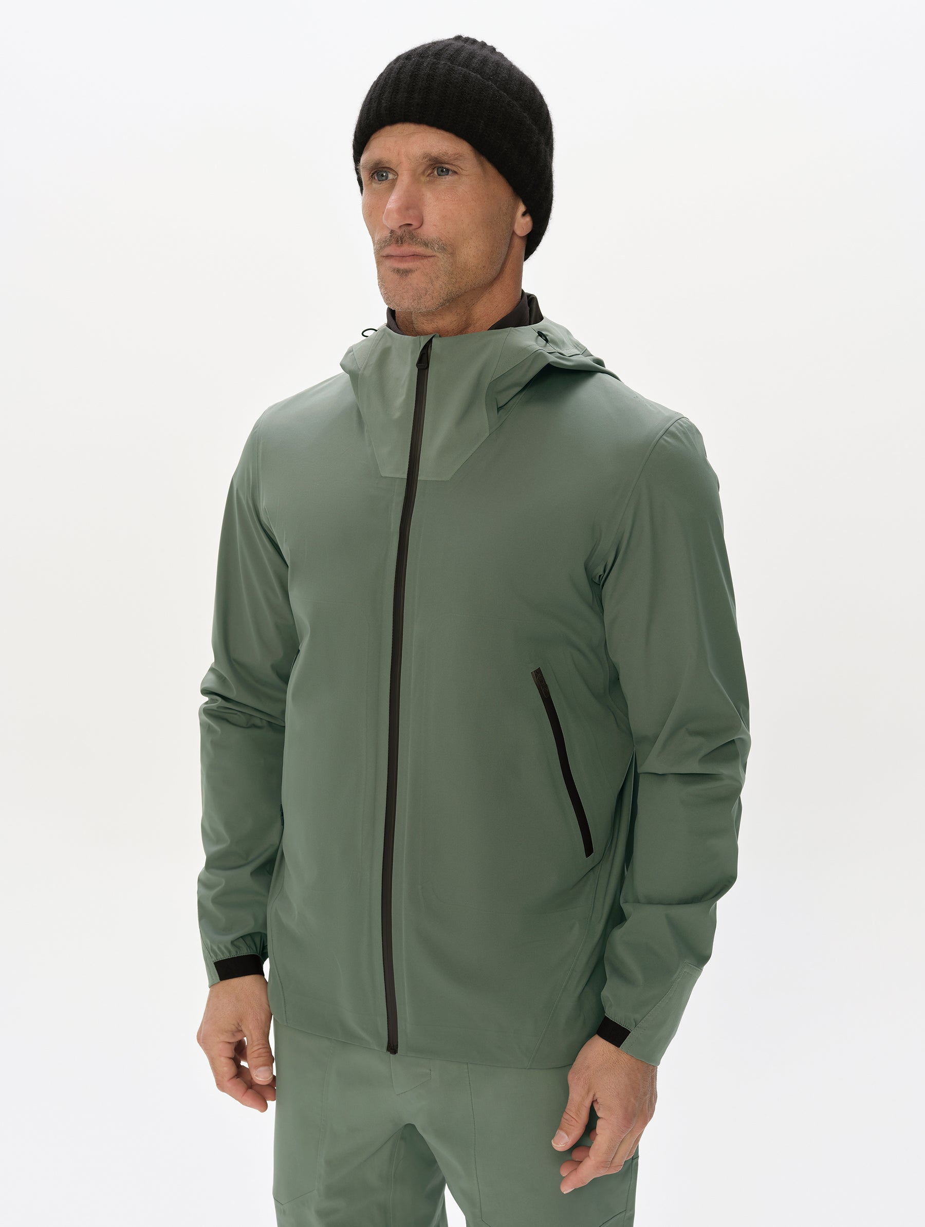 Front, upper-body view of man wearing the Frontier Hooded Shell Jacket in Gunmetal from AETHER Apparel.
