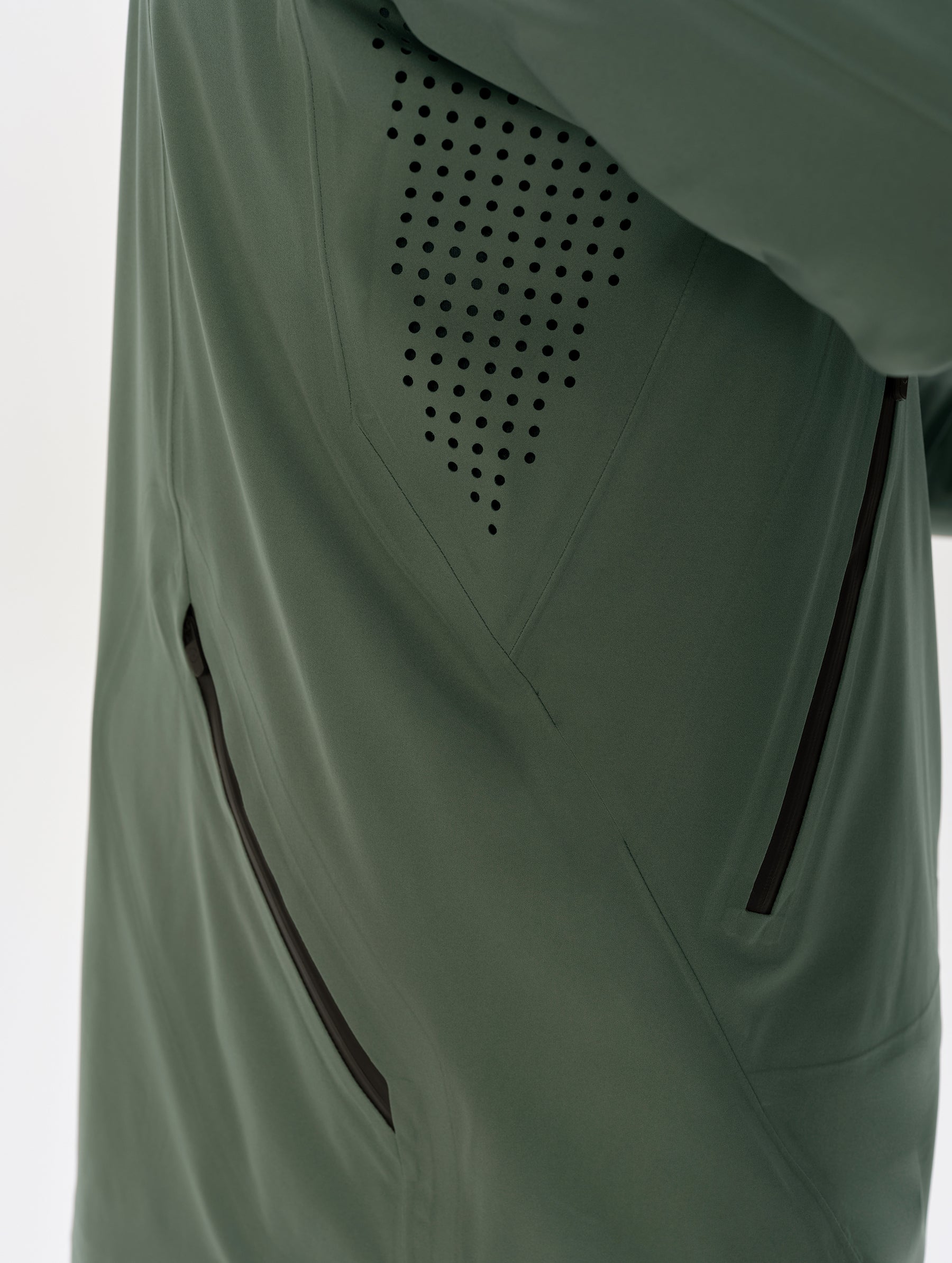 Closeup detailed view of the laser-cut underarm ventilation holes on the Frontier Hooded Shell Jacket in Gunmetal from AETHER Apparel.
