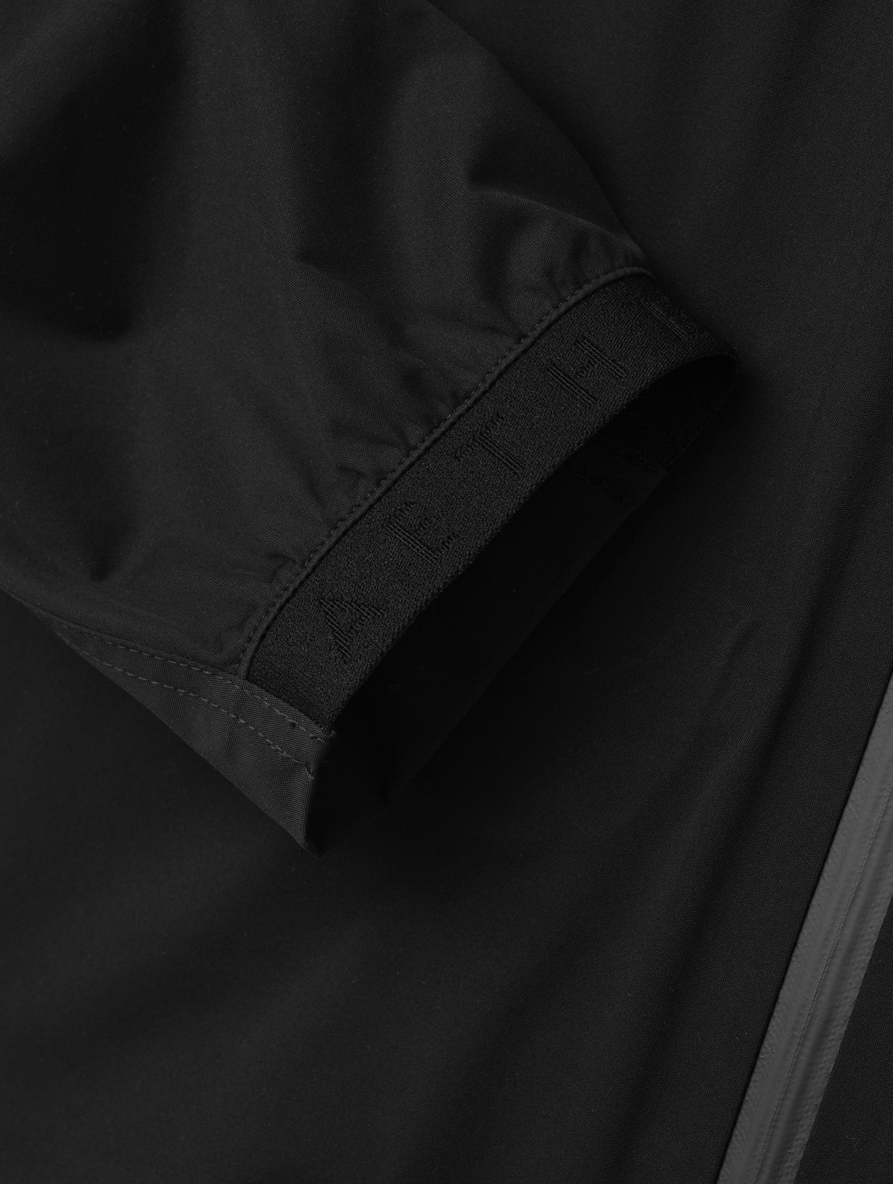 Closeup detailed view of one of the elasticated sleeve cuffs on the Frontier Pant in Onyx Black from AETHER Apparel.