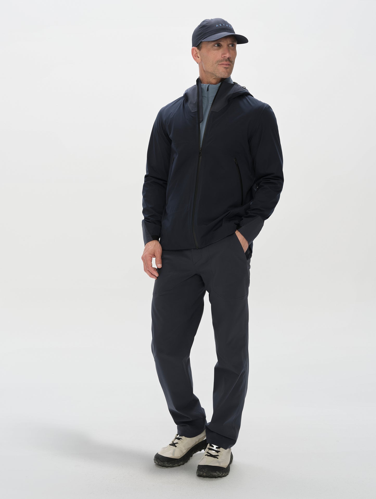 Front, full-body view of man wearing the Frontier Pant in Total Eclipse dark blue from AETHER Apparel.