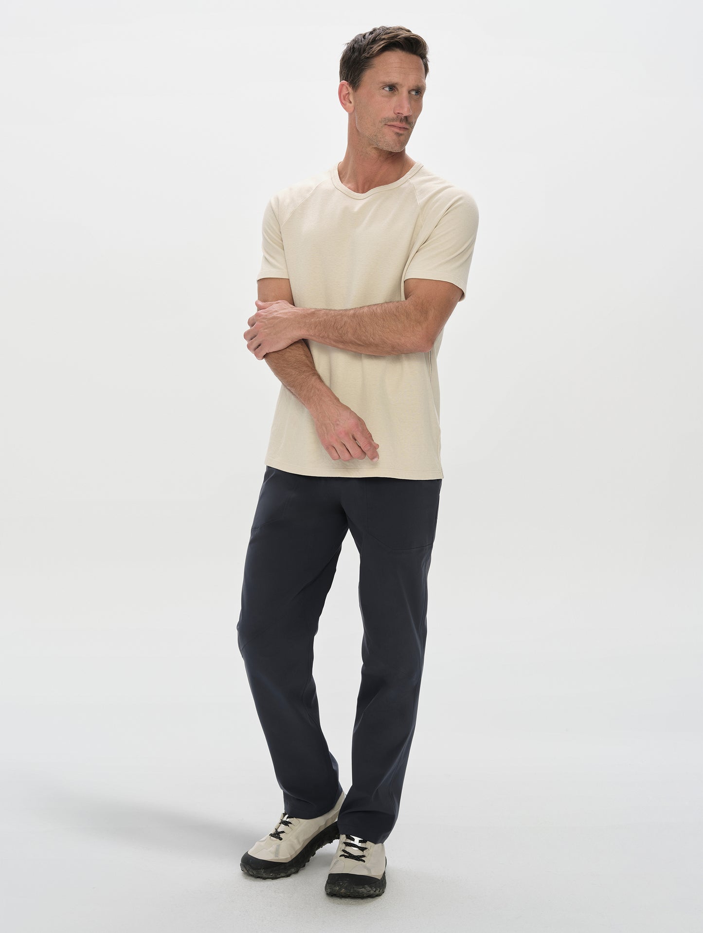 Front, full-body view of man wearing the Frontier Pant in Total Eclipse dark blue from AETHER Apparel.
