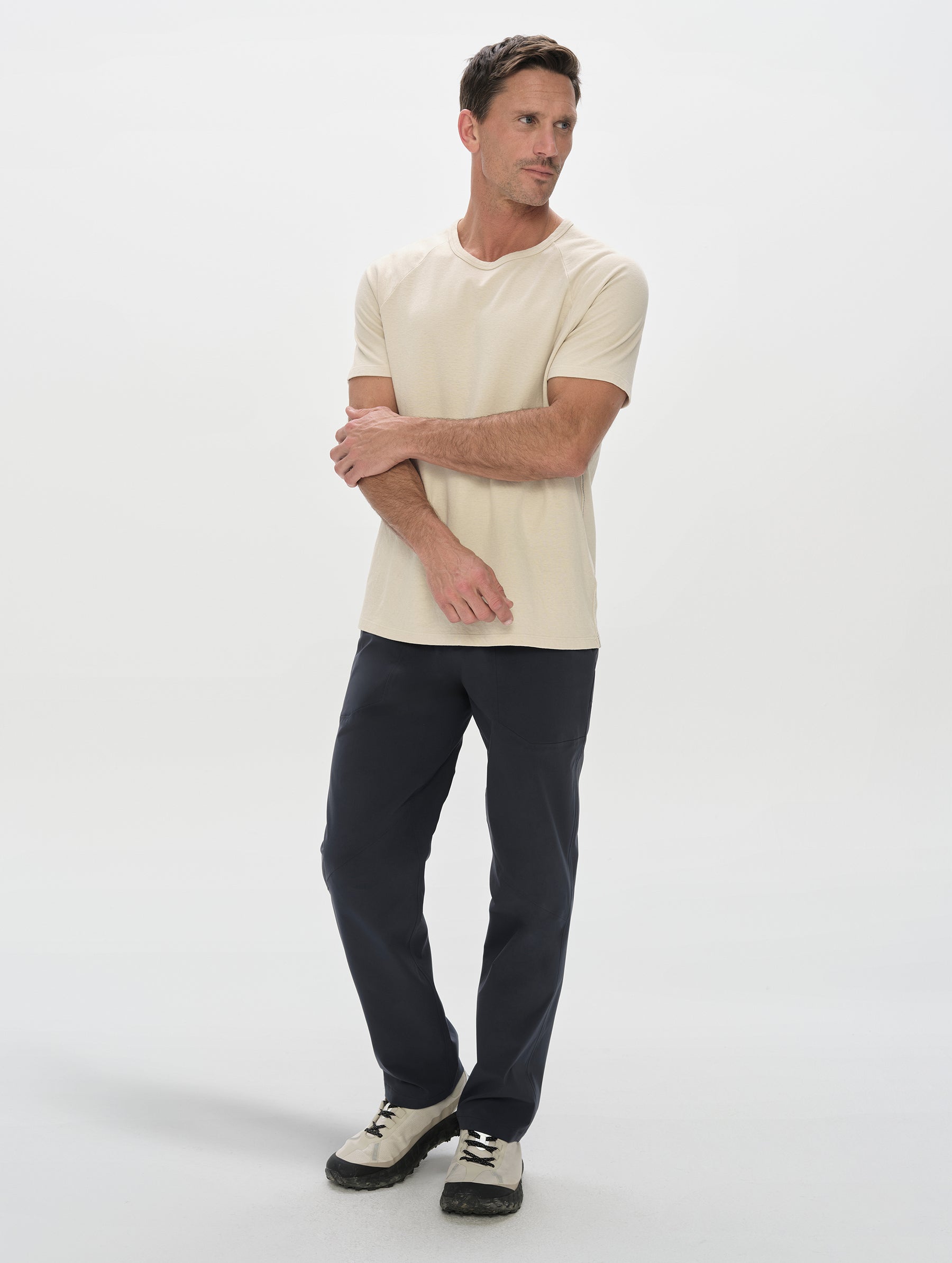 Front, full-body view of man wearing the Frontier Pant in Total Eclipse dark blue from AETHER Apparel.
