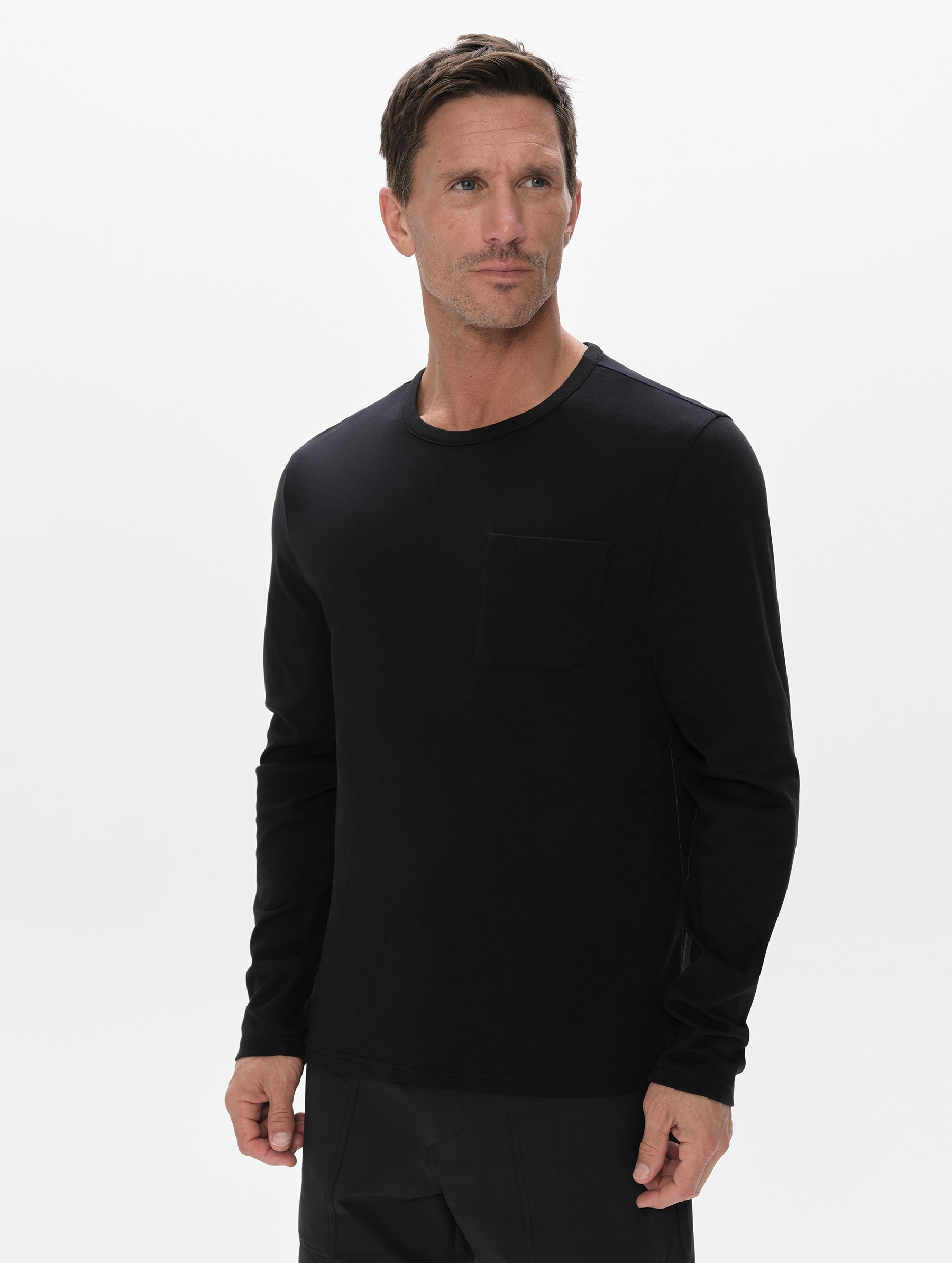 Front, upper-body view of man wearing the Harlow Premium Long-Sleeve Tee in Onyx Black from AETHER Apparel.