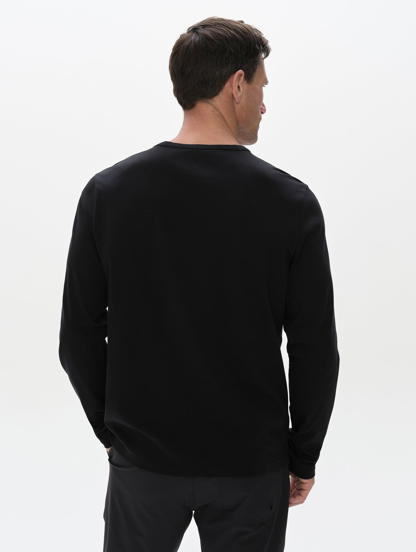 Rear, upper-body view of man wearing the Harlow Premium Long-Sleeve Tee in Onyx Black from AETHER Apparel.