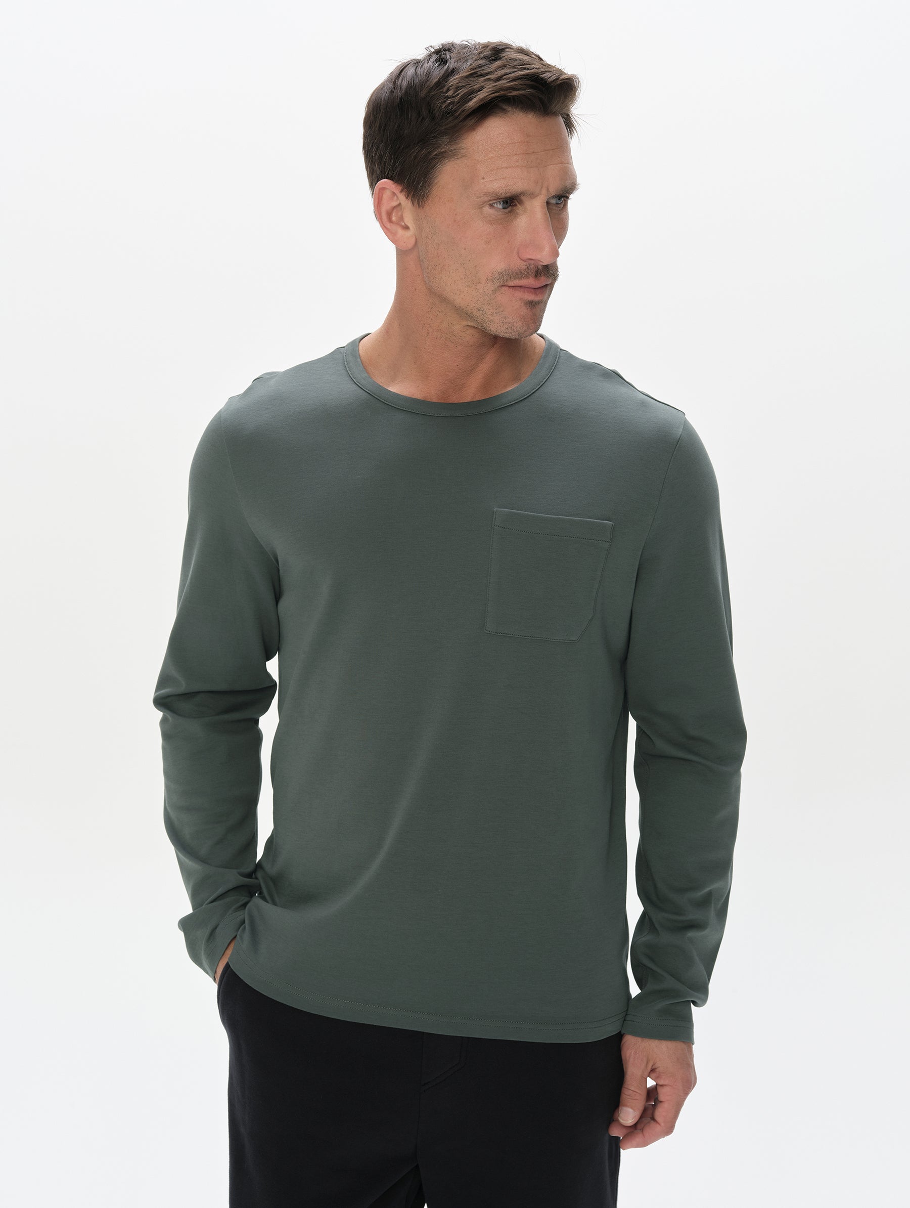 Front, upper-body view of man wearing Harlow Premium Long-Sleeve Tee in Saville Green  from AETHER Apparel.