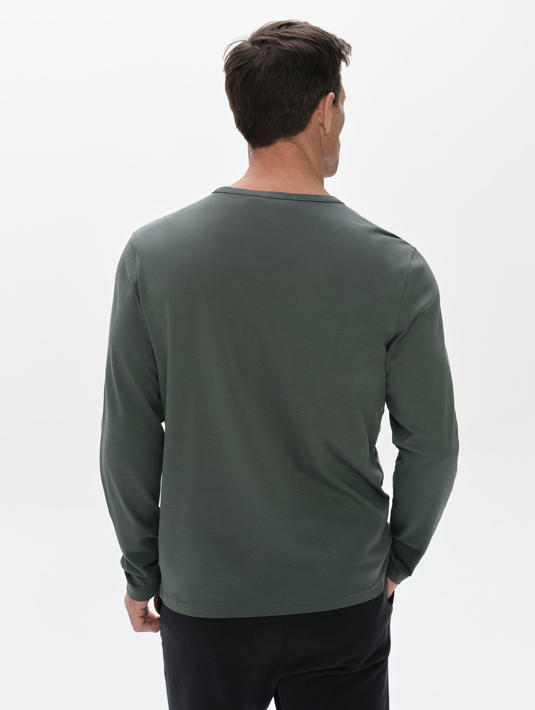 Rear, upper-body view of man wearing Harlow Premium Long-Sleeve Tee in Saville Green from AETHER Apparel.