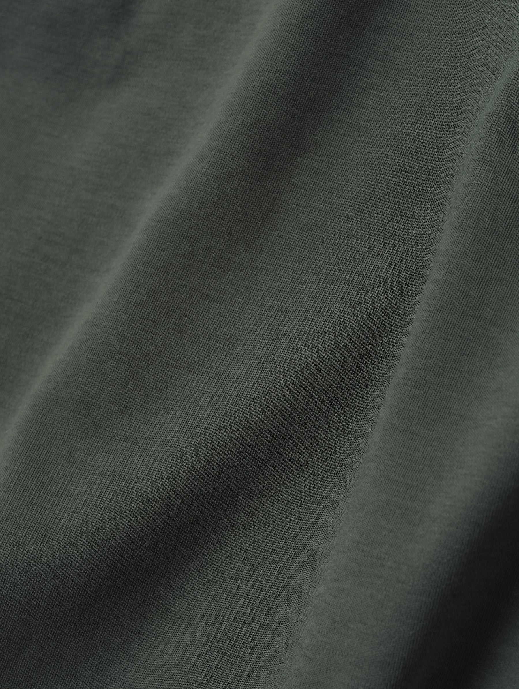 Closeup detailed view of the fabric on the Harlow Premium Long-Sleeve Tee in Saville Green from AETHER Apparel.