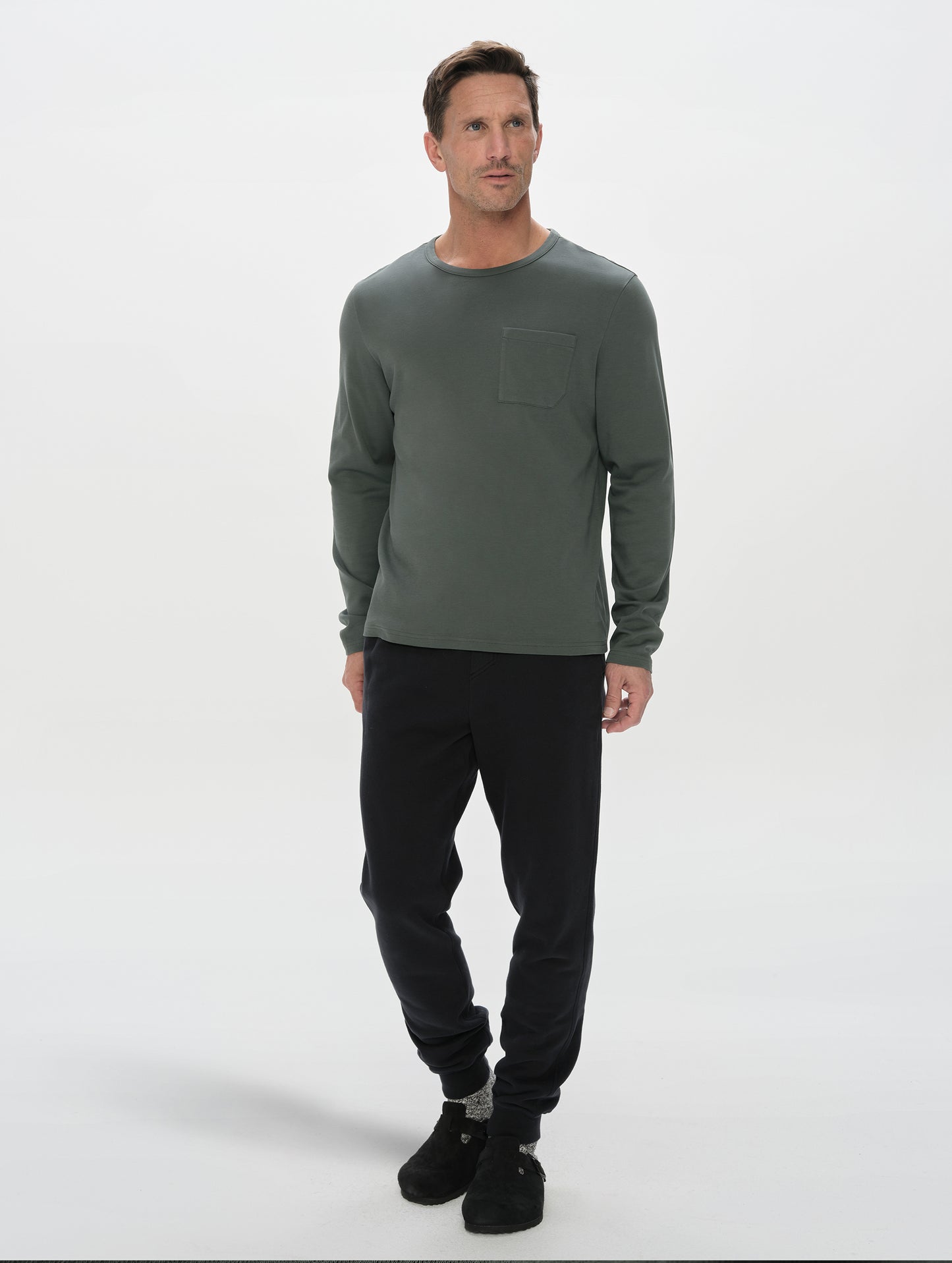 Front, full-body view of man wearing Harlow Premium Long-Sleeve Tee in Saville Green from AETHER Apparel.