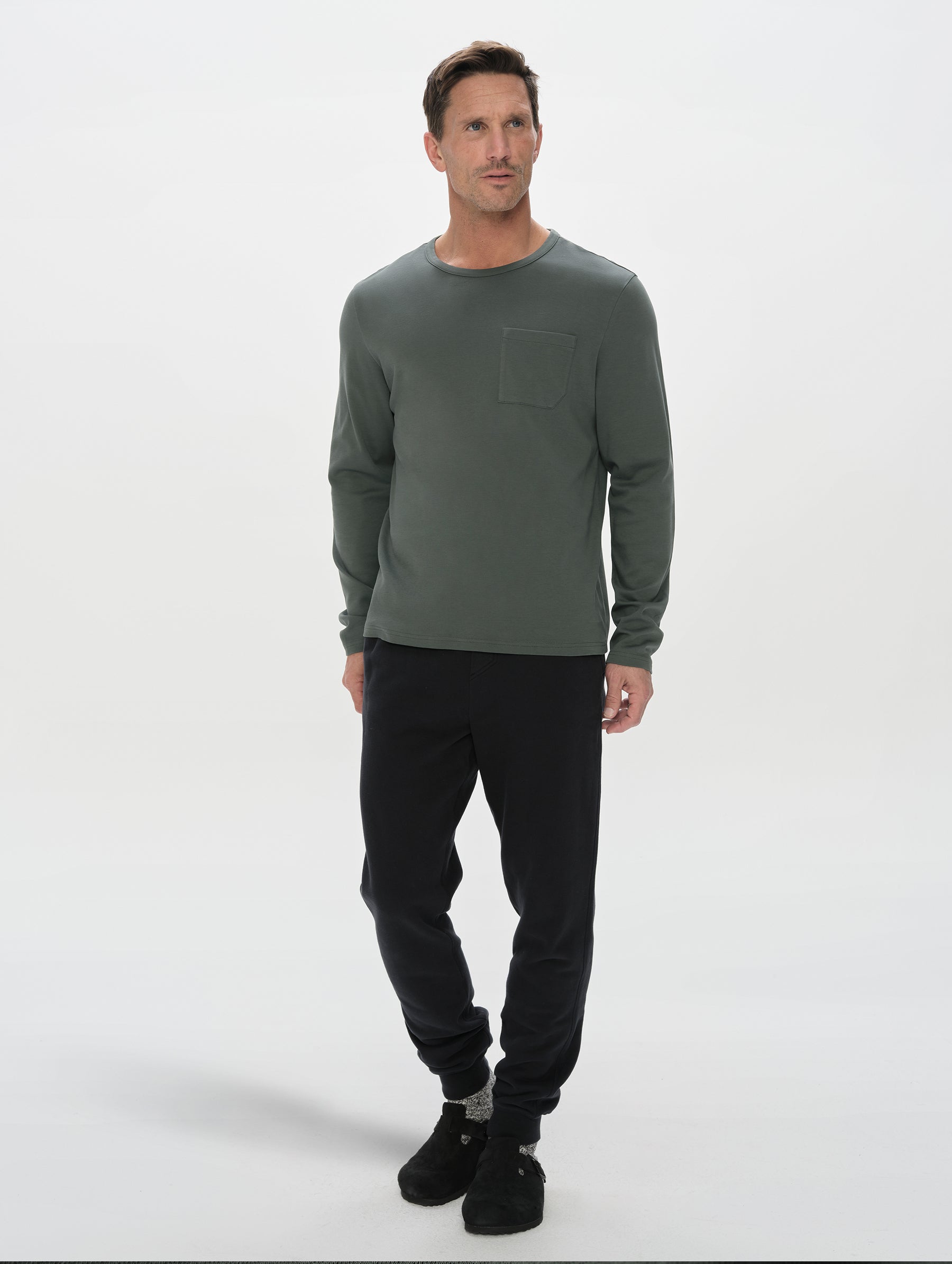 Front, full-body view of man wearing Harlow Premium Long-Sleeve Tee in Saville Green from AETHER Apparel.