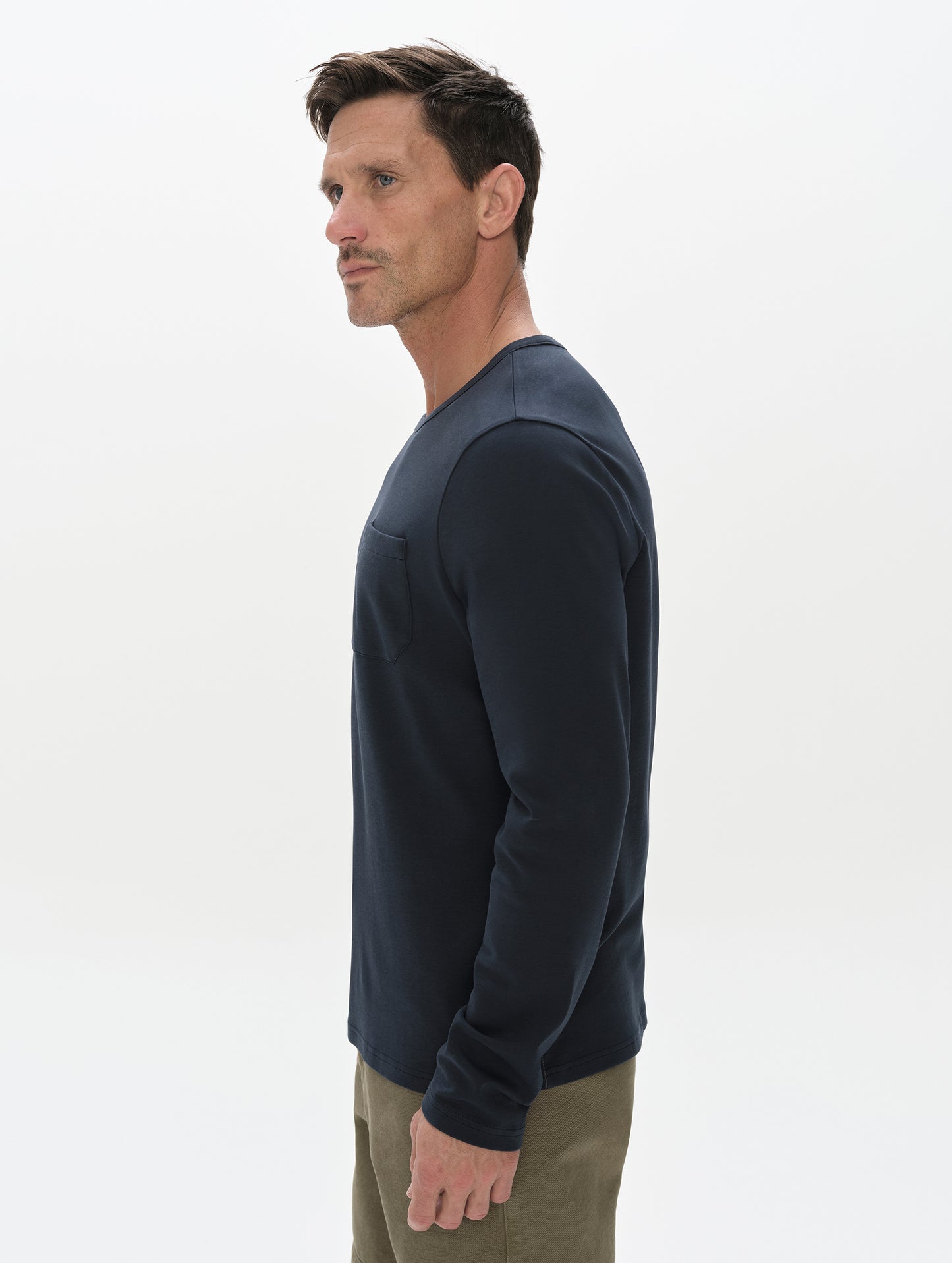 Side profile, upper-body view of man wearing Harlow Premium Long-Sleeve Tee in Total Eclipse from AETHER Apparel.