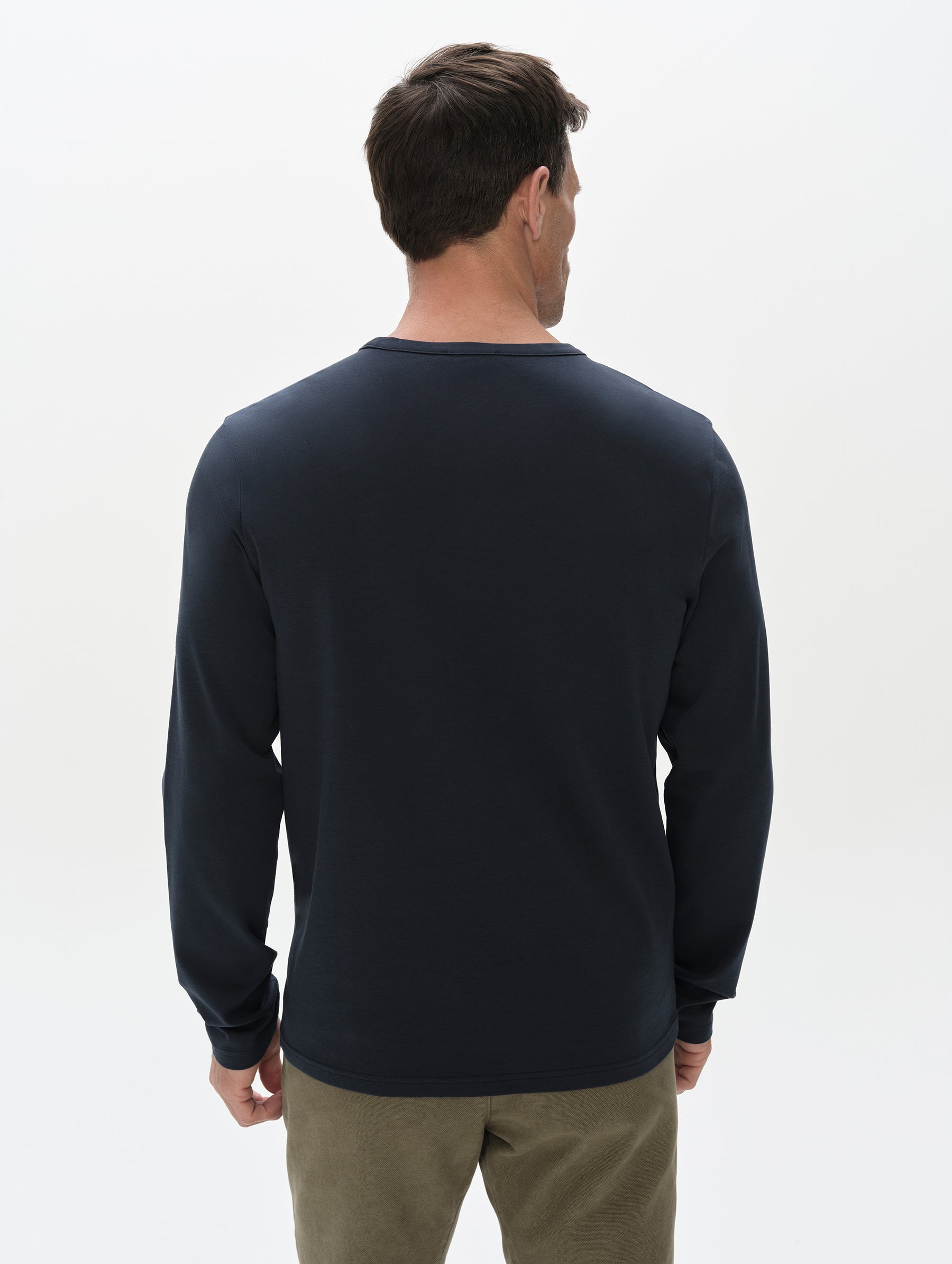 Rear, upper-body view of man wearing Harlow Premium Long-Sleeve Tee in Total Eclipse from AETHER Apparel.