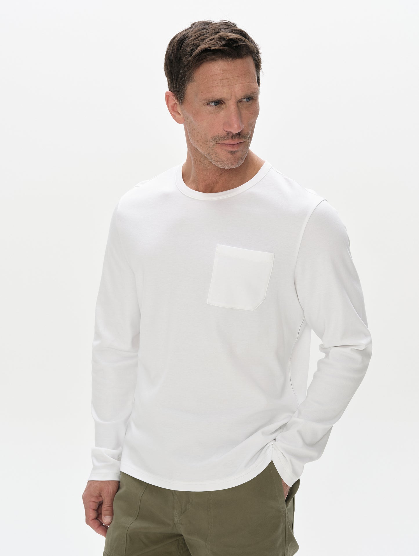 Front, upper-body view of man wearing Harlow Premium Long-Sleeve Tee in White from AETHER Apparel.