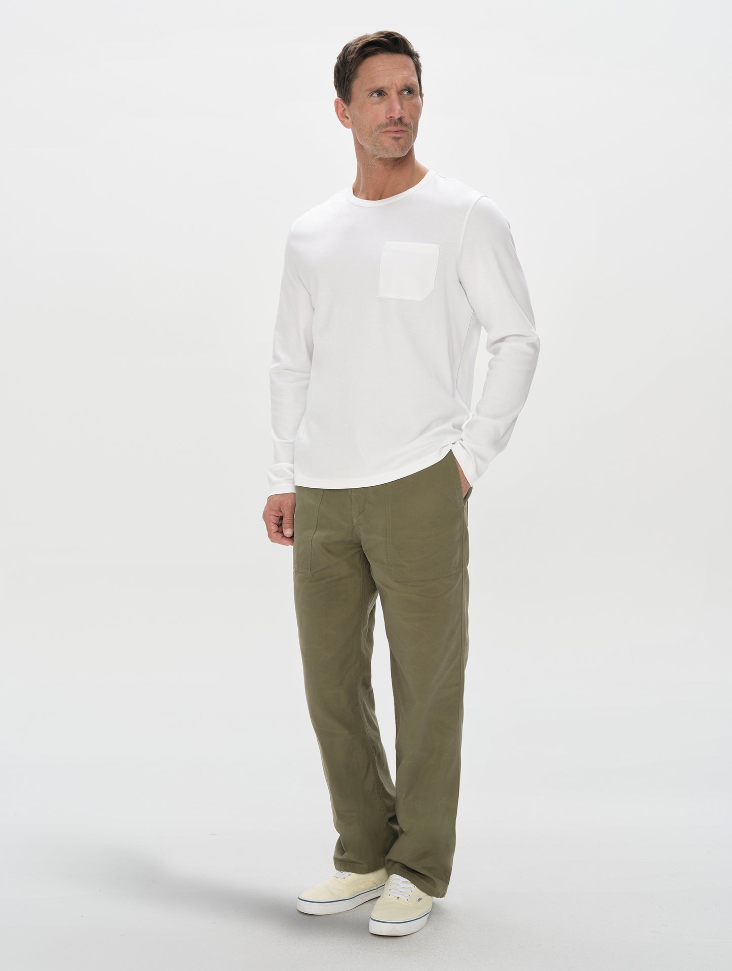 Front, full-body view of man wearing Harlow Premium Long-Sleeve Tee in White from AETHER Apparel.