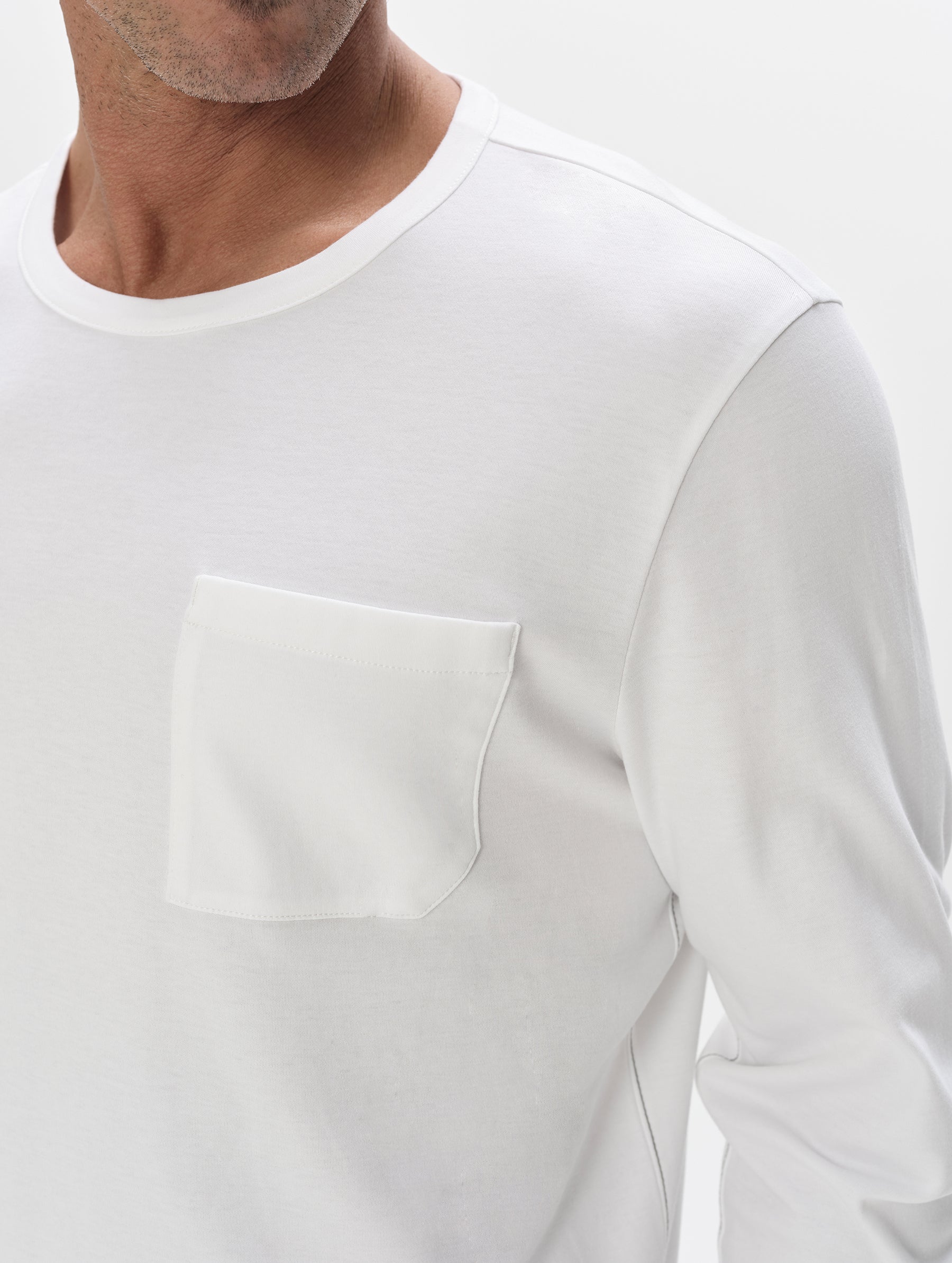 Closeup detailed view of the patch pocket on the Harlow Premium Long-Sleeve Tee in White from AETHER Apparel.