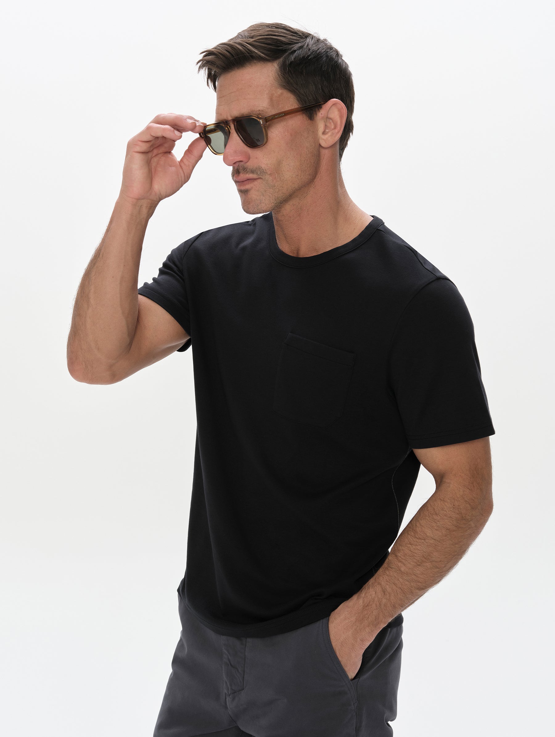 Front, 3/4, upper-body view of man wearing the Harlow Premium Tee in Onyx Black from AETHER Apparel.