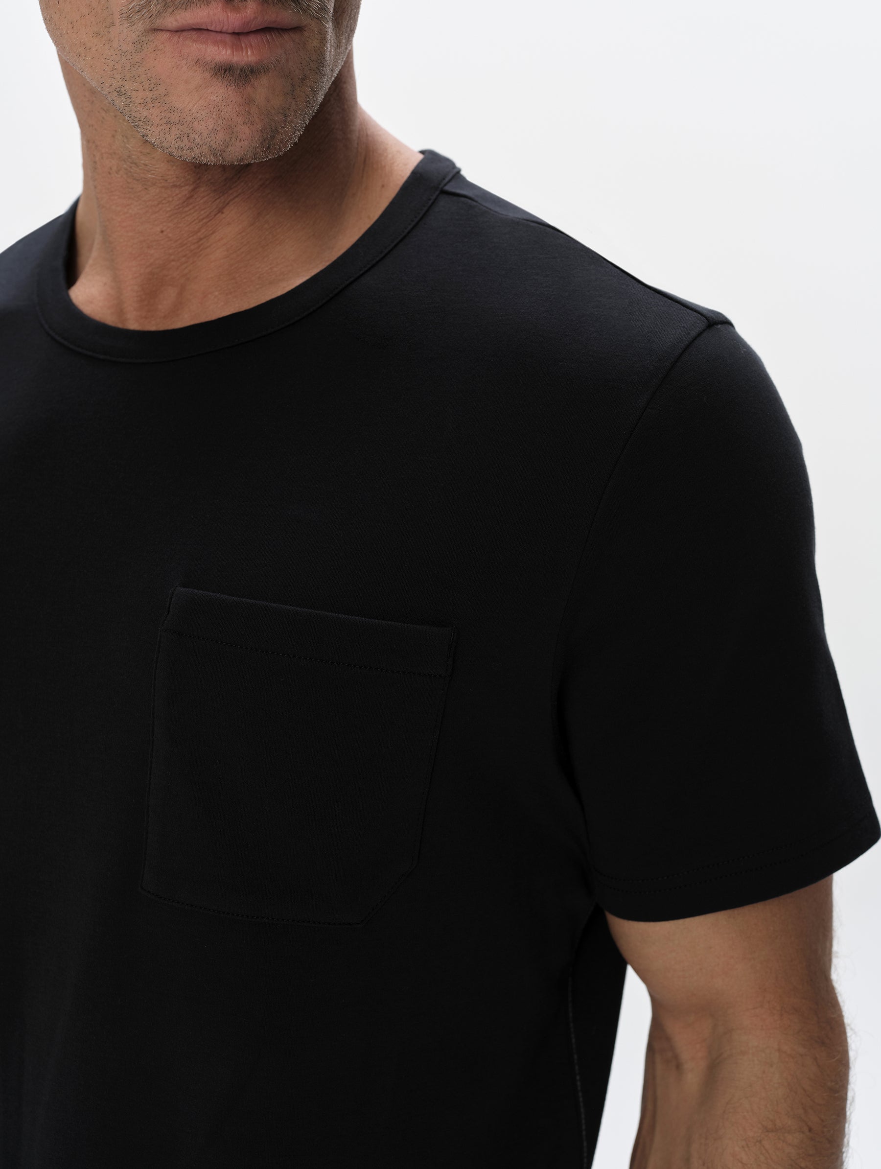 Closeup detailed view of the patch pocket and shoulder on the Harlow Premium Tee in Onyx Black from AETHER Apparel.