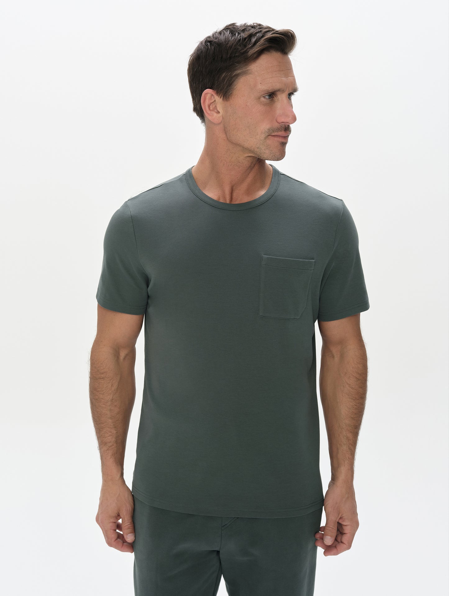 Front, upper-body view of man wearing Harlow Premium Tee in Saville Green from AETHER Apparel.