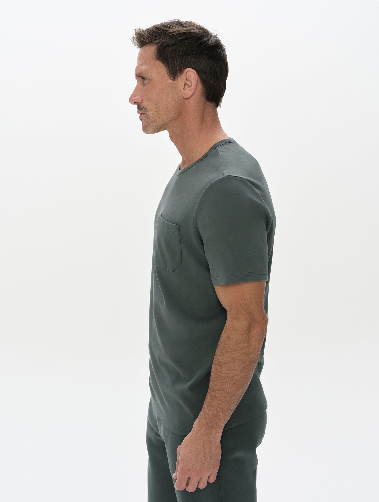 Side profile, upper-body view of man wearing Harlow Premium Tee in Saville Green from AETHER Apparel.