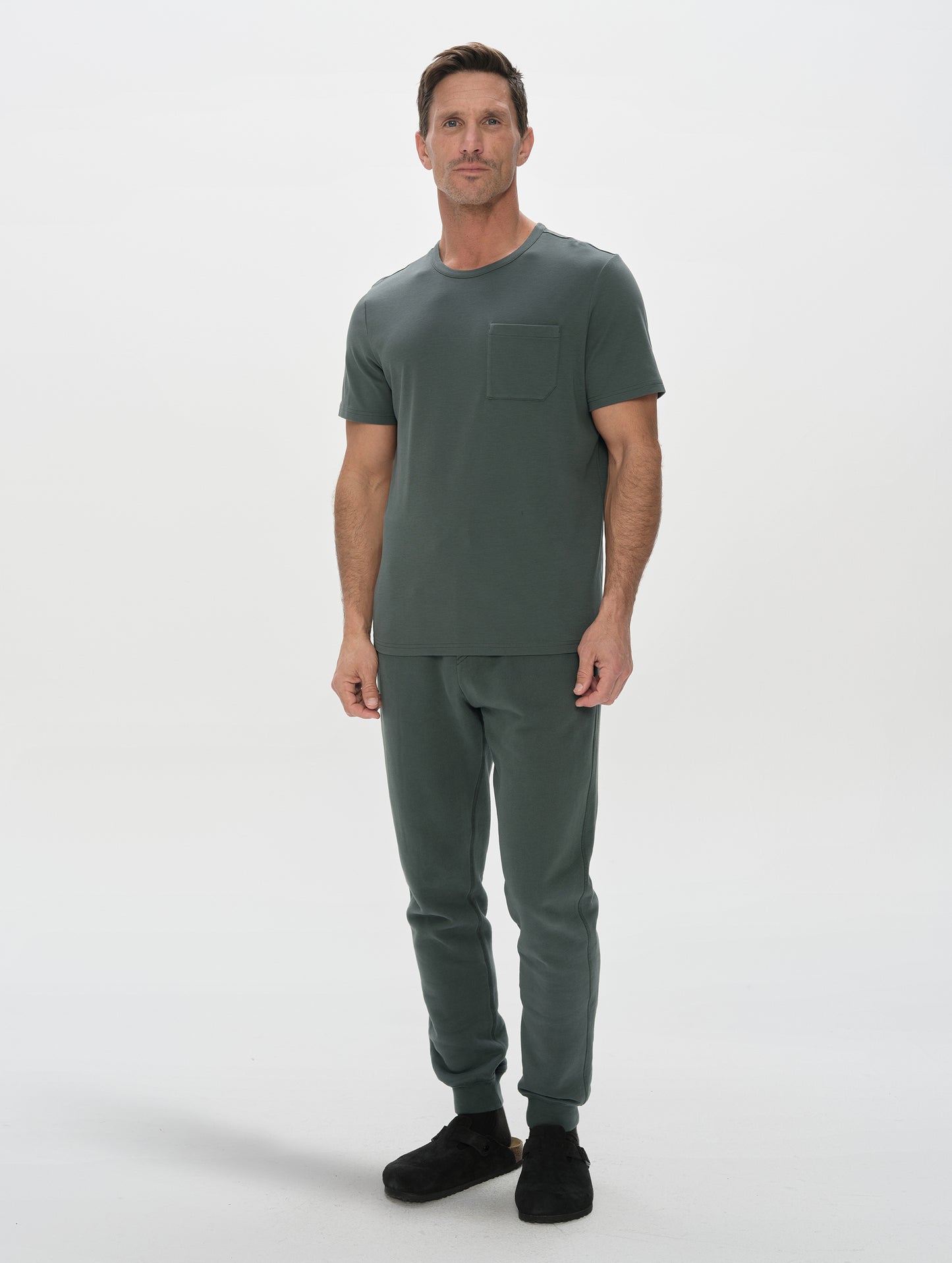 Front, full-body view of man wearing Harlow Premium Tee in Saville Green from AETHER Apparel.