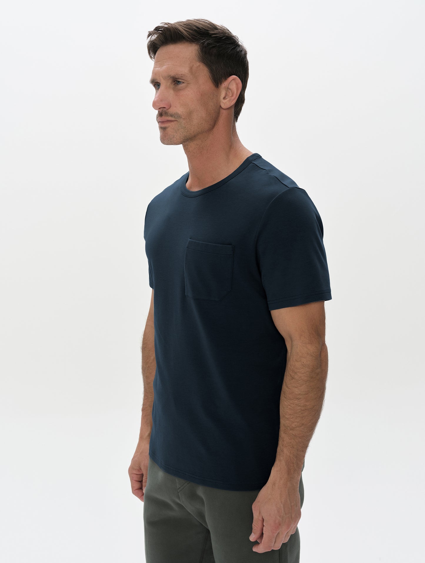 Front, 3/4, upper-body view of man wearing Harlow Premium Tee in Total Eclipse from AETHER Apparel.
