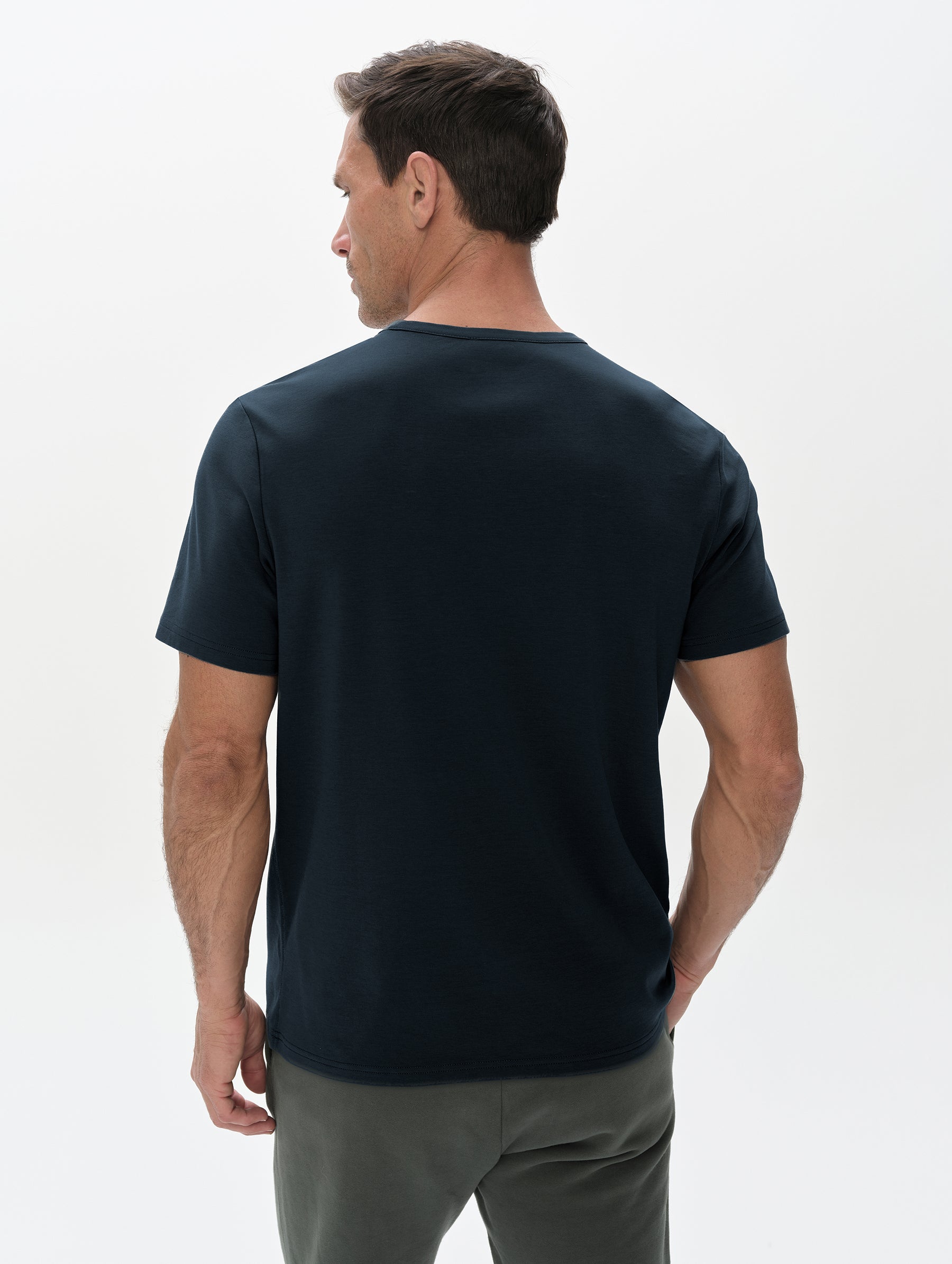 Rear, upper-body view of man wearing Harlow Premium Tee in Total Eclipse from AETHER Apparel.