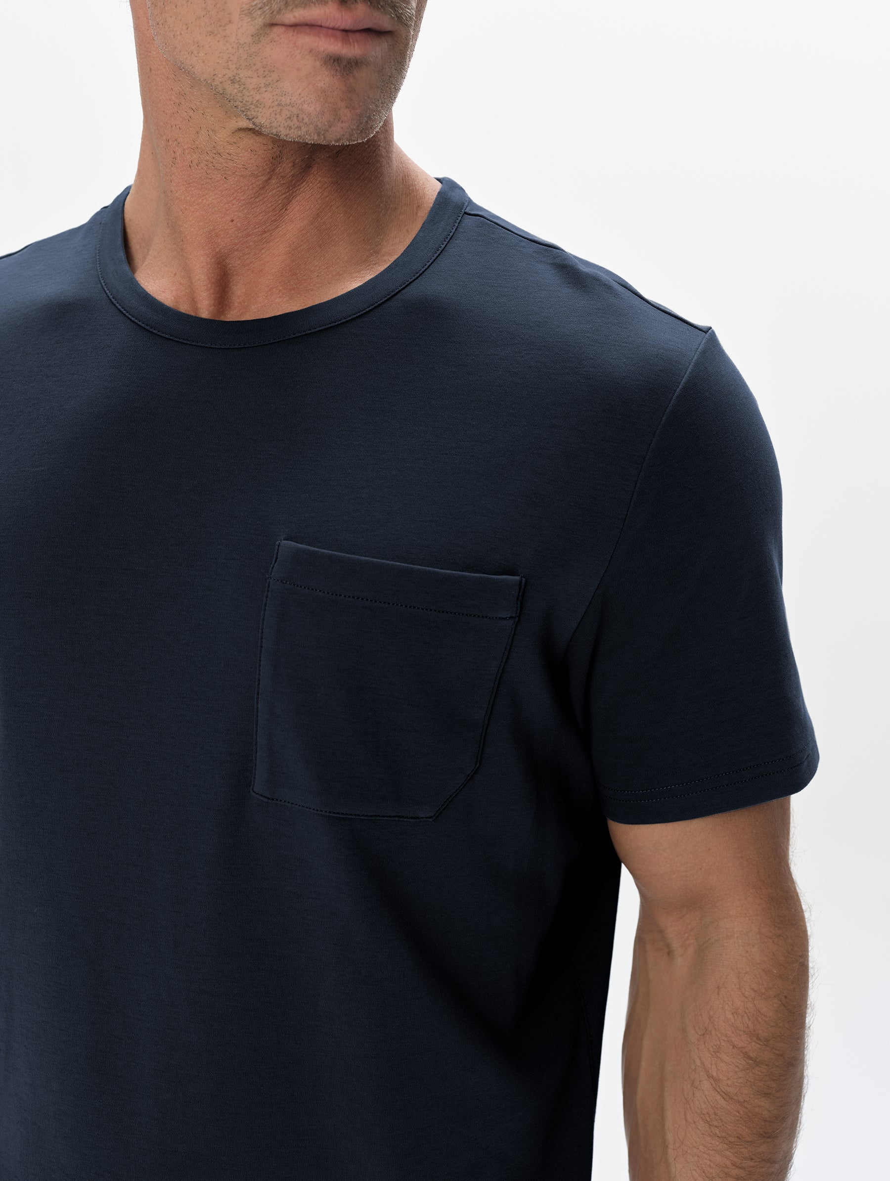 Closeup detailed view of the patch pocket and shoulder of the Harlow Premium Tee in Total Eclipse from AETHER Apparel.