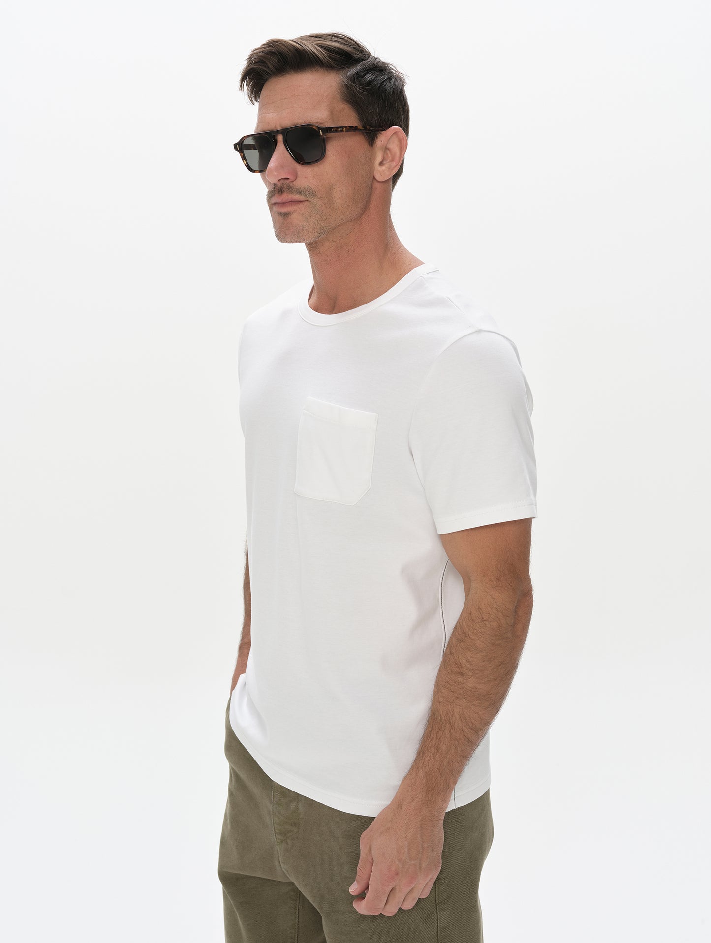Front, 3/4, upper-body view of man wearing Harlow Premium Tee in White from AETHER Apparel.