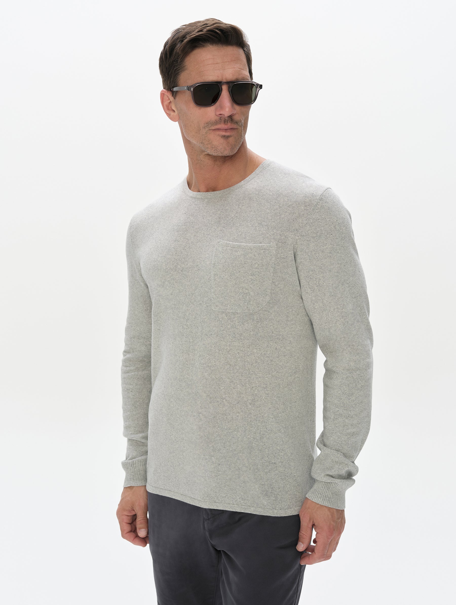 Front, upper-body view of the man wearing the Aero Crewneck Sweater 2.0 in Alumino Grey from AETHER Apparel.