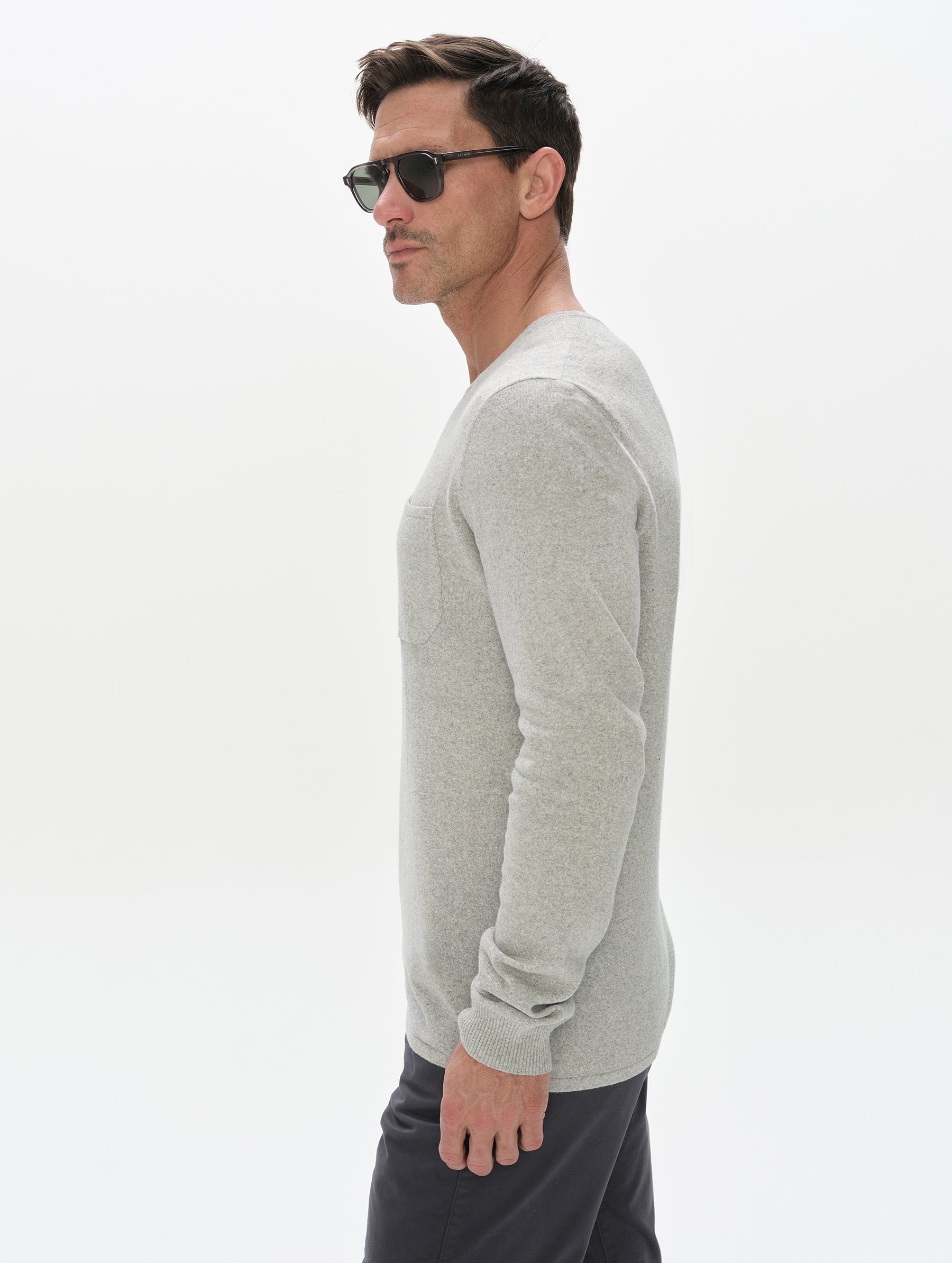 Side profile, upper-body view of the man wearing the Aero Crewneck Sweater 2.0 in Alumino Grey from AETHER Apparel.
