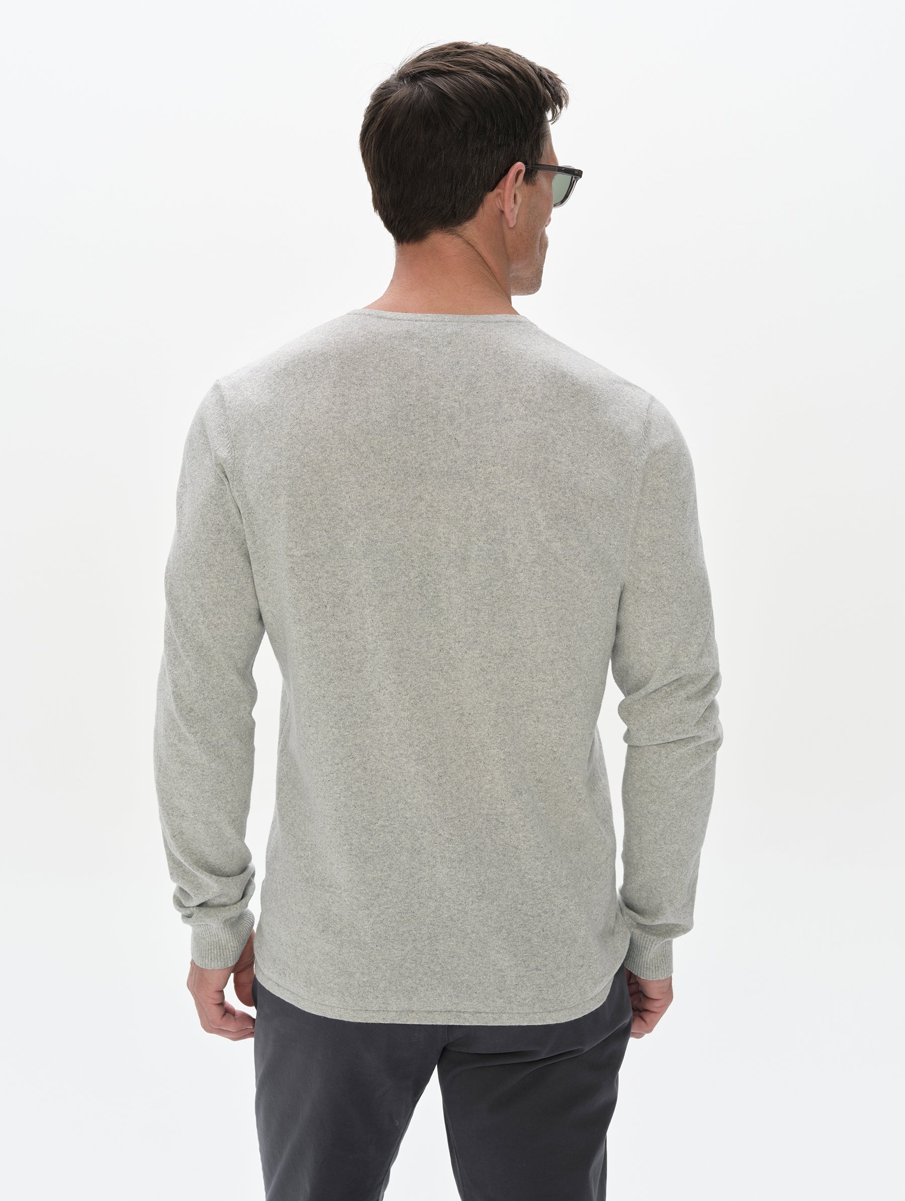 Rear, upper-body view of the man wearing the Aero Crewneck Sweater 2.0 in Alumino Grey from AETHER Apparel.