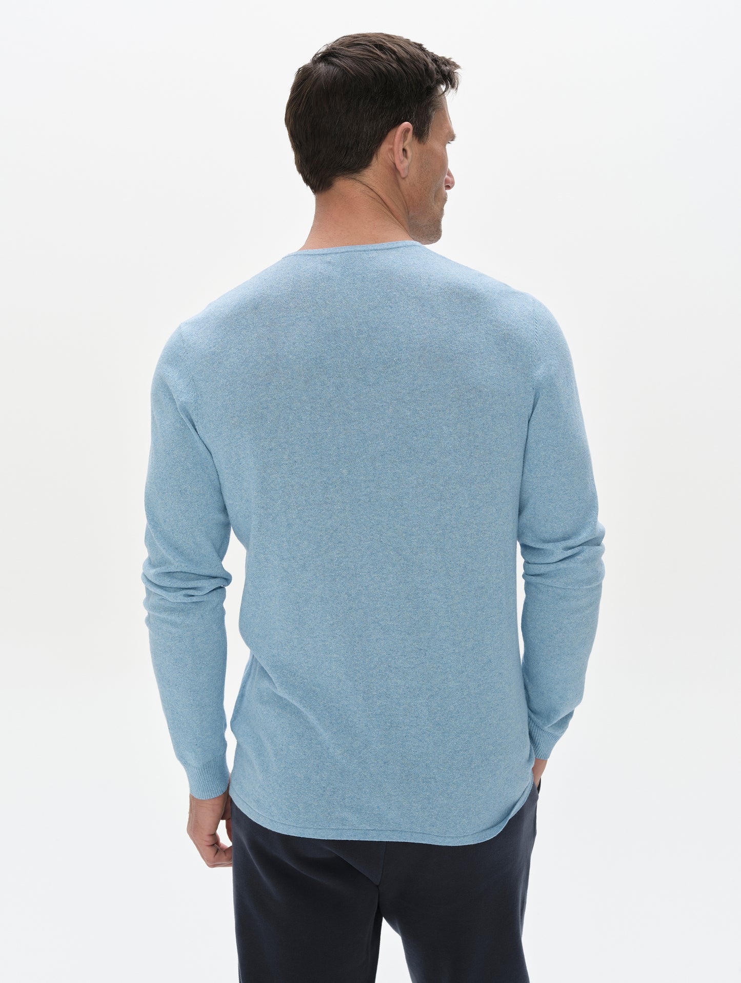 Rear, upper-body view of the man wearing the Aero Crewneck Sweater 2.0 in Cloud Blue from AETHER Apparel.