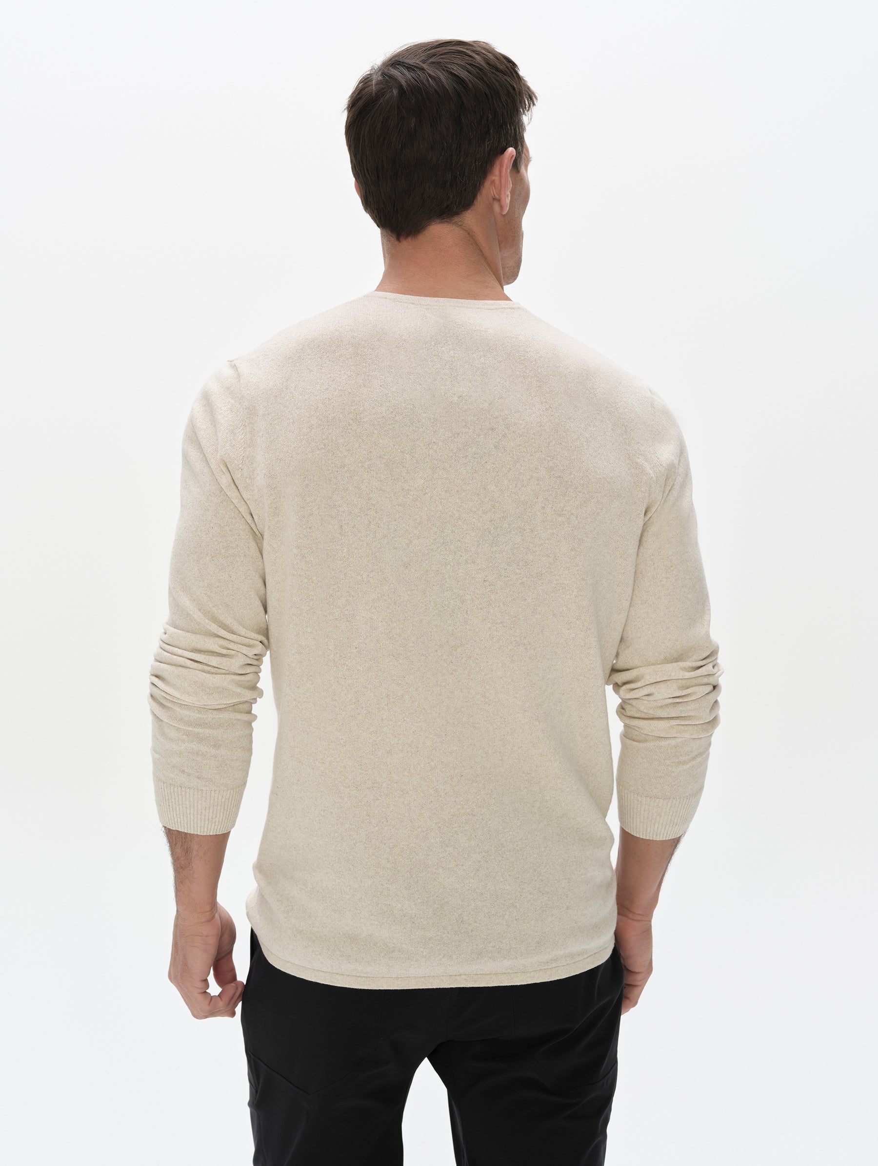 Side profile, upper-body view of the man wearing the Aero Crewneck Sweater 2.0 in Lino Tan from AETHER Apparel.