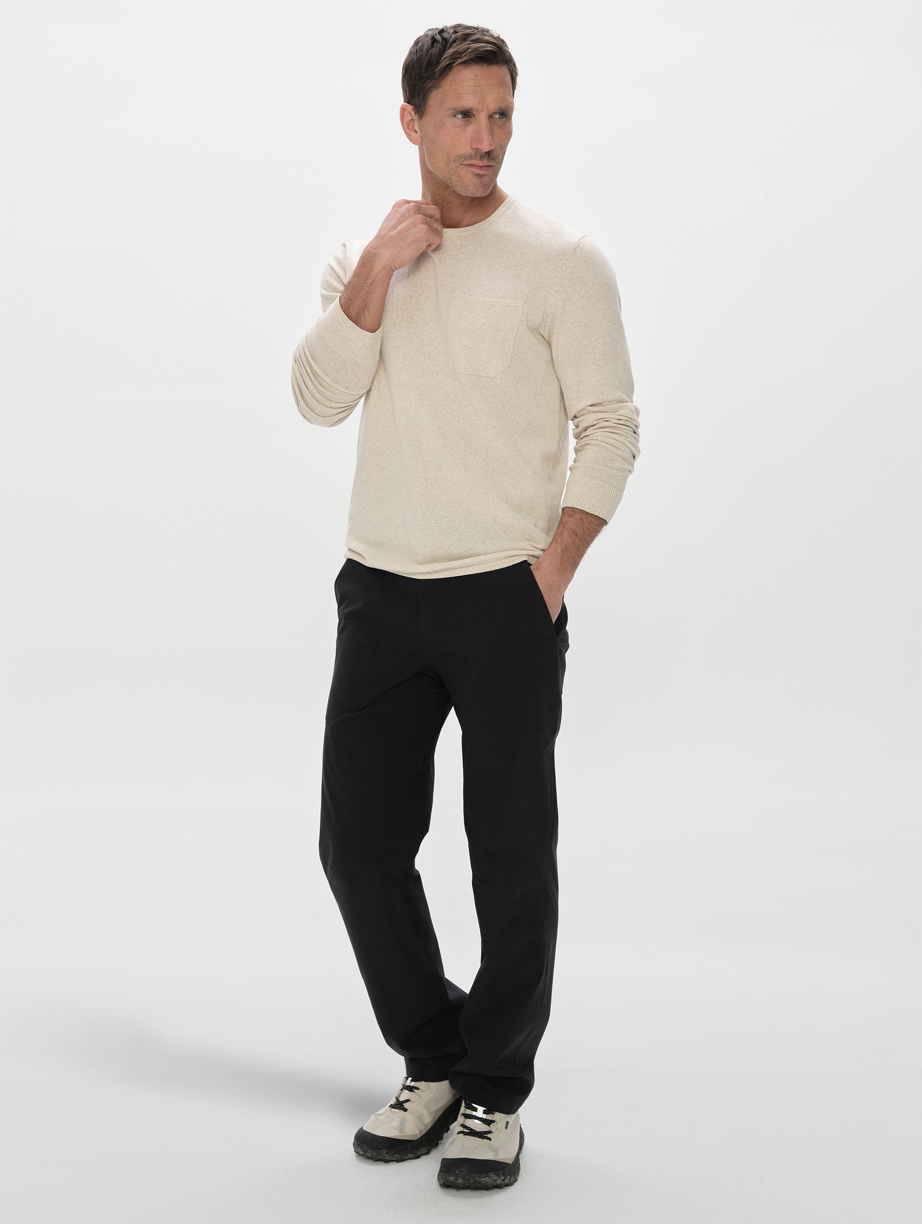 Front, 3/4, full-body view of the man wearing the Aero Crewneck Sweater 2.0 in Lino Tan from AETHER Apparel.