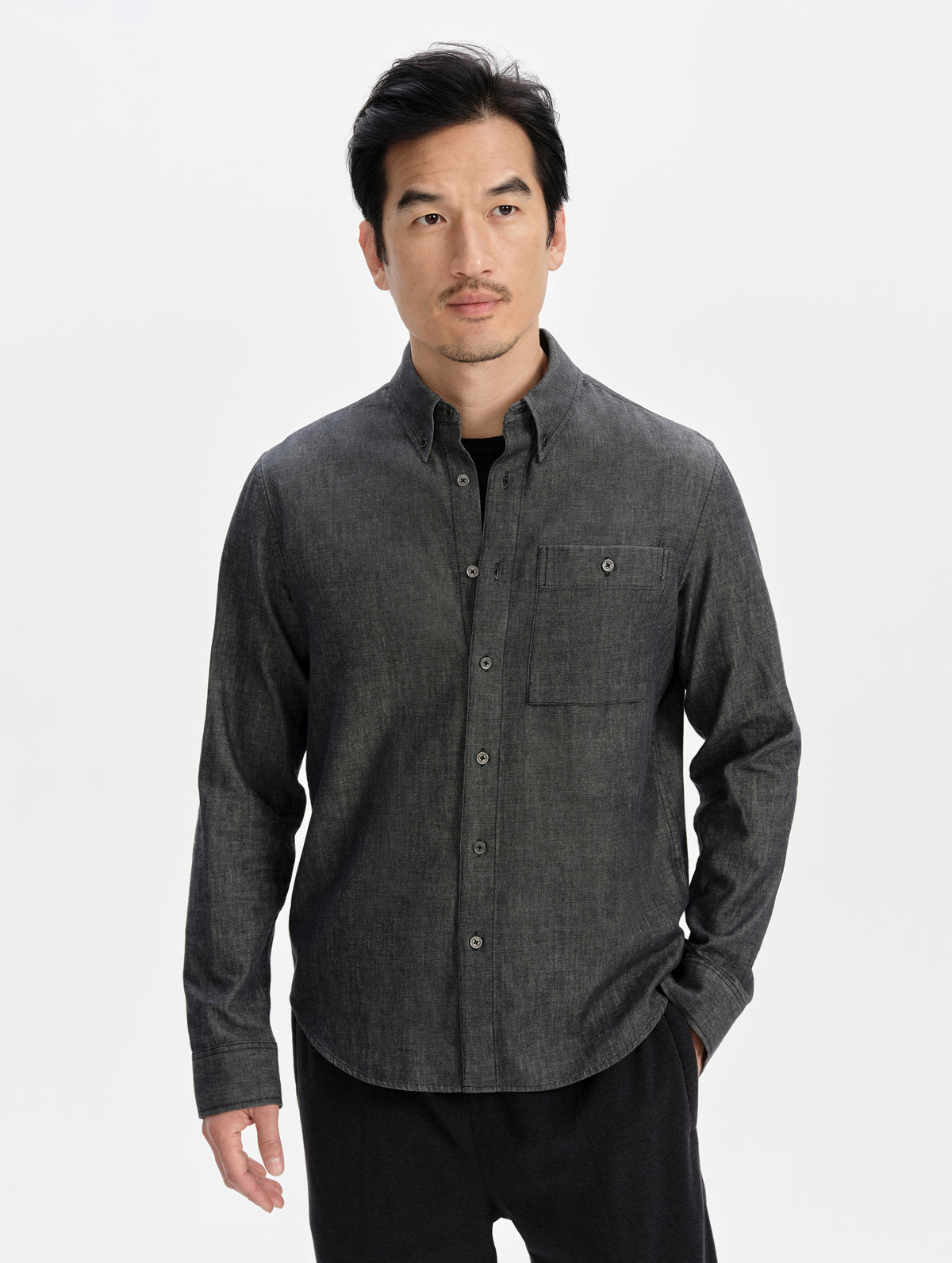 Front upper-body view of man wearing the Alder Chambray Button-Down in Black from AETHER Apparel.