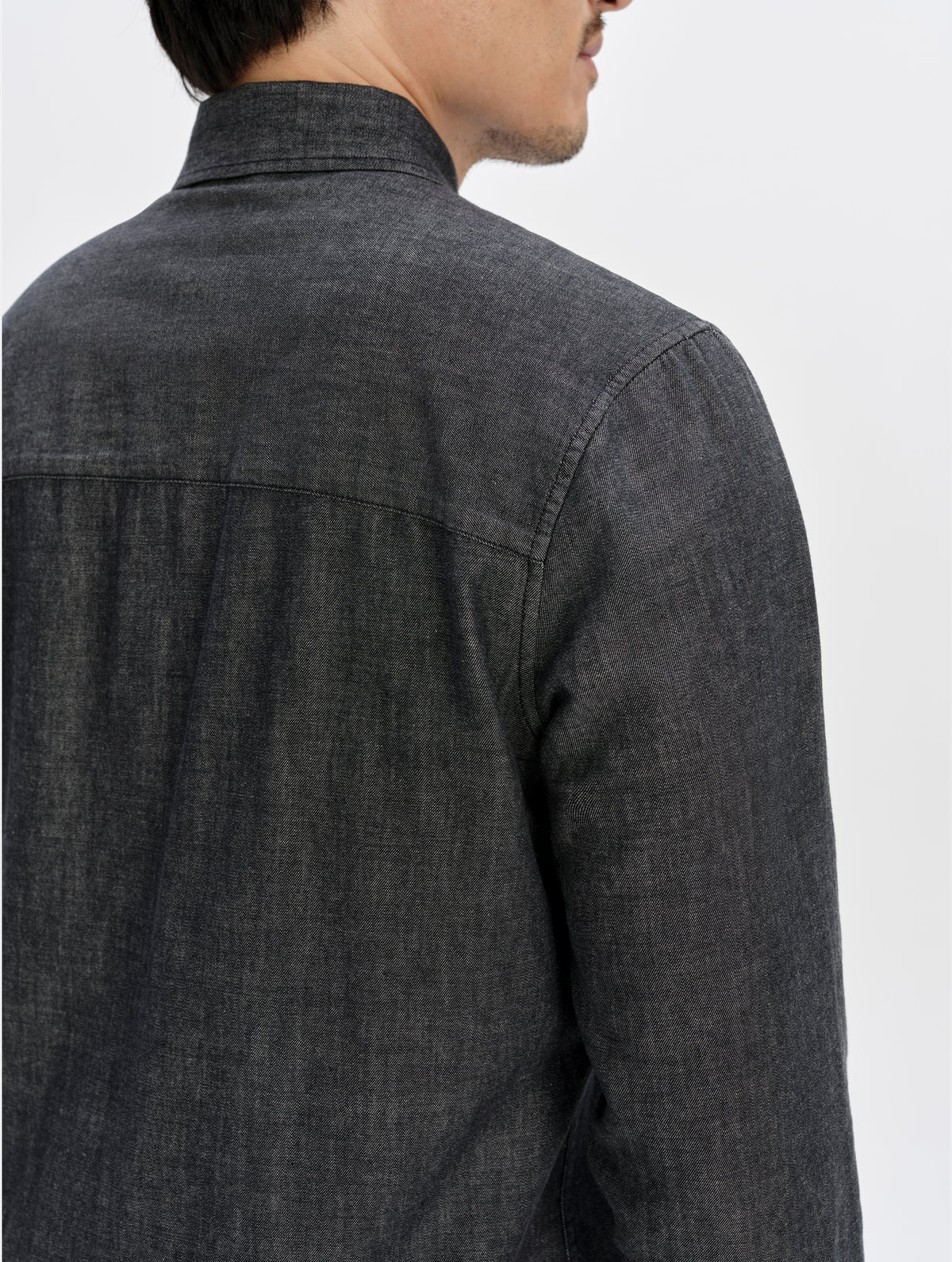 View of the rear shoulder seams on the Alder Chambray Button-Down in Black from AETHER Apparel.