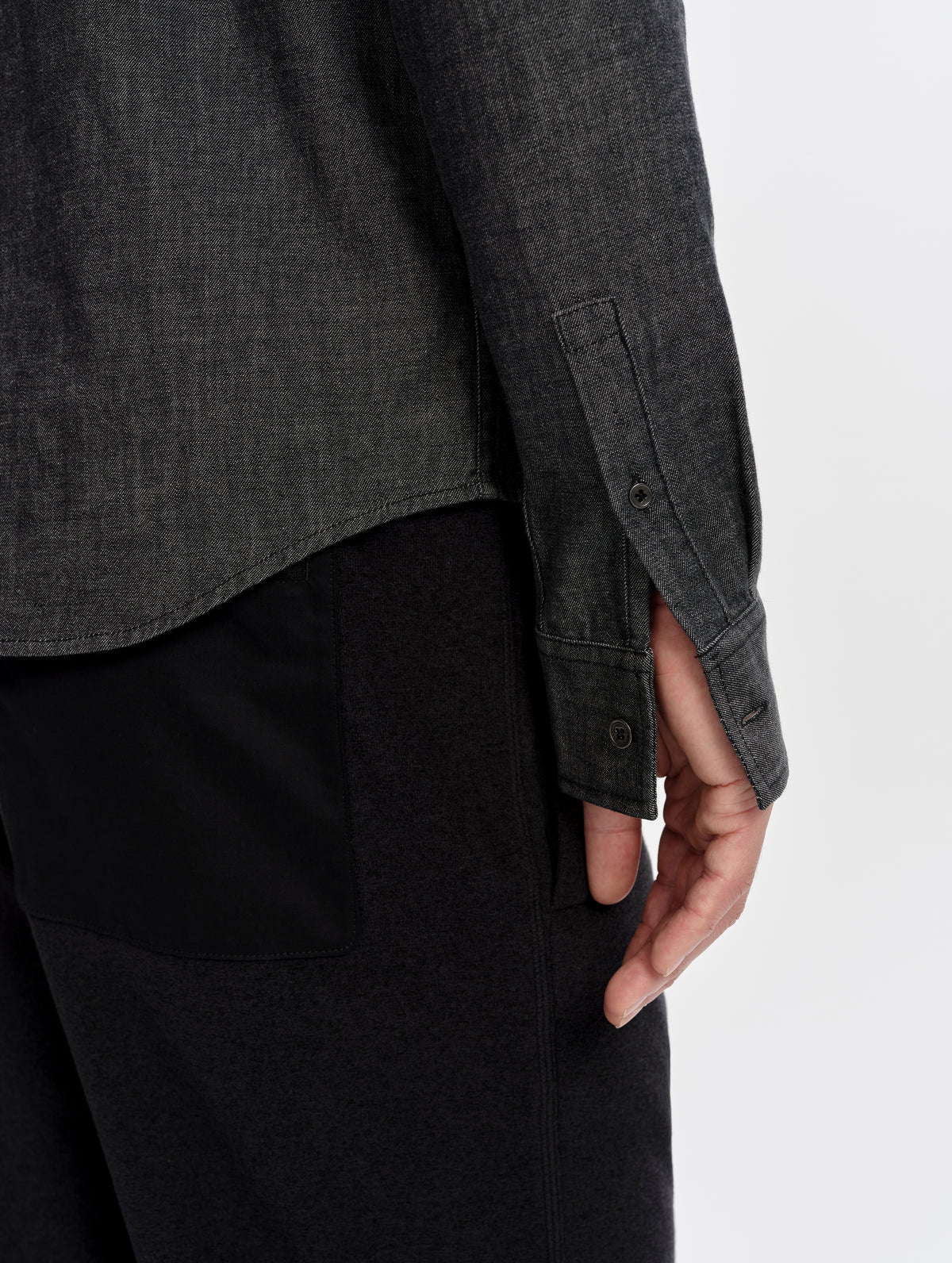 Closeup detailed view of the button-equipped sleeve cuffs on the Alder Chambray Button-Down in Black from AETHER Apparel.