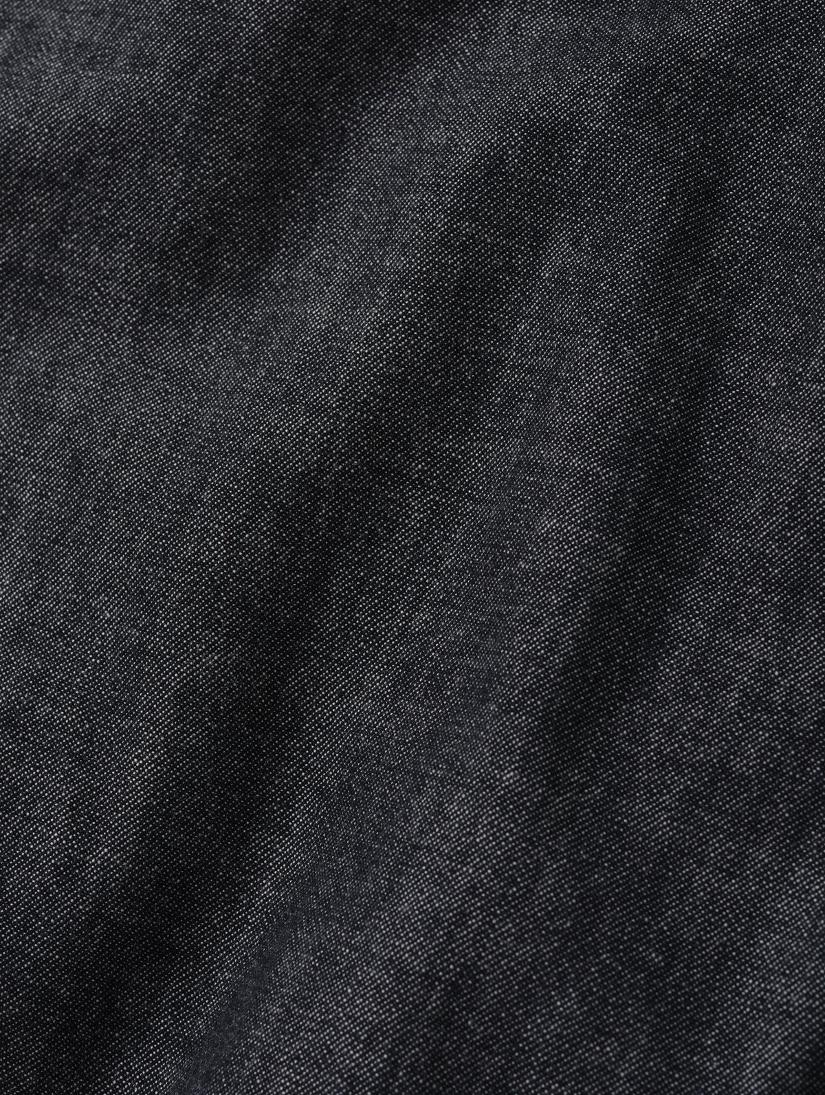 Closeup detailed view of the Chambray denim construction on the Alder Chambray Button-Down in Black from AETHER Apparel. 
