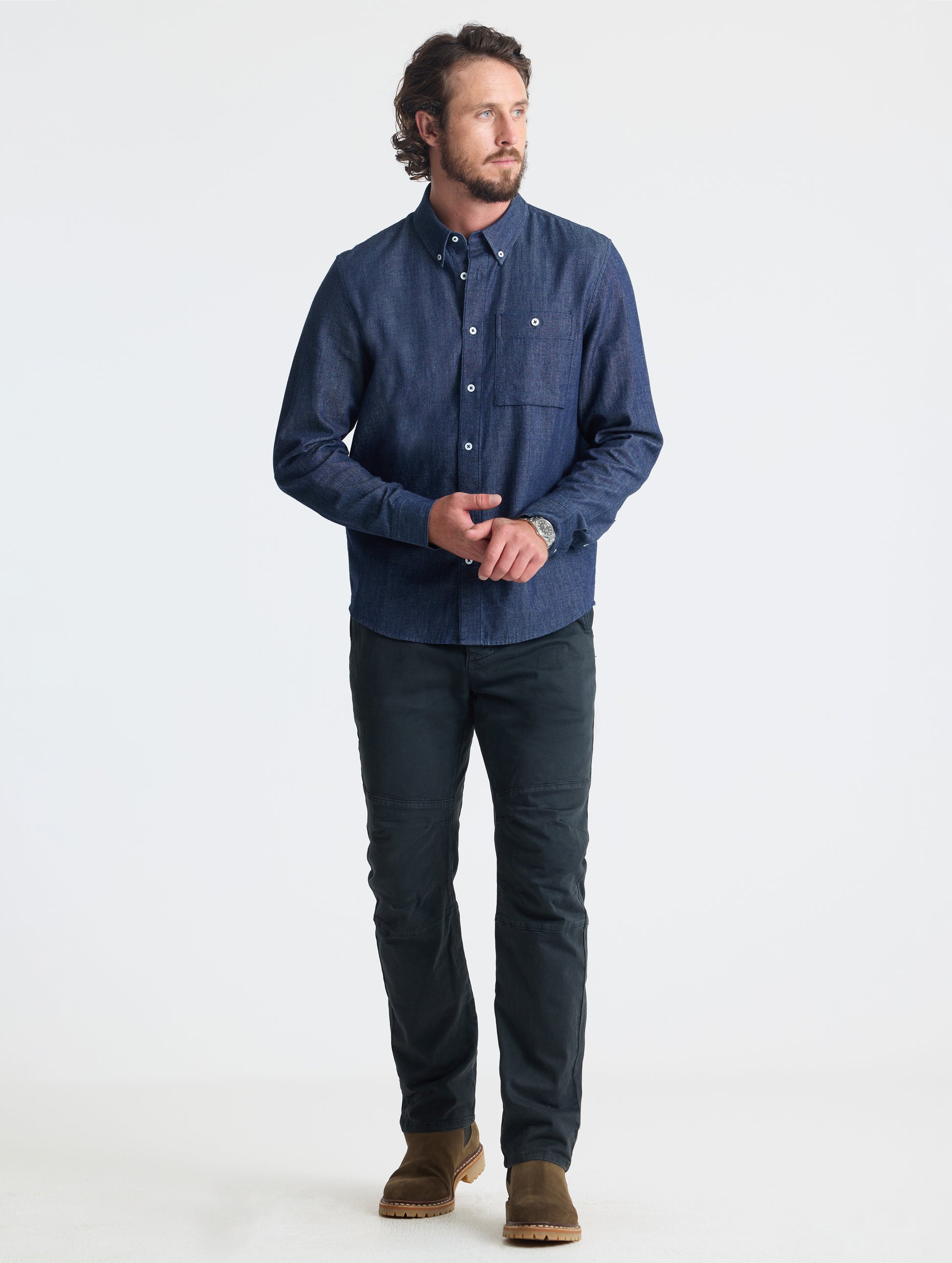 Full body view of man wearing Alder Chambray Button-Down in Dark Blue from AETHER Apparel.