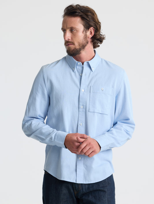 Front view of man wearing Alder Chambray Button-Down in Light Blue from AETHER Apparel.