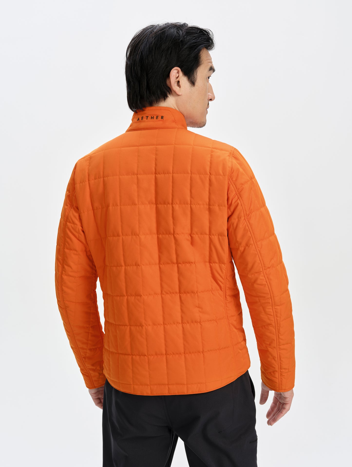 Rear upper-body view of man wearing the Alto Jacket 2.0 in Autumn Orange from AETHER Apparel.