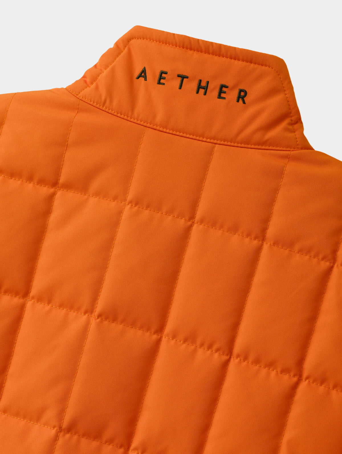 Closeup detailed view of the embroidered AETHER wordmark on the back of the collar on the Alto Jacket 2.0 in Autumn Orange from AETHER Apparel.